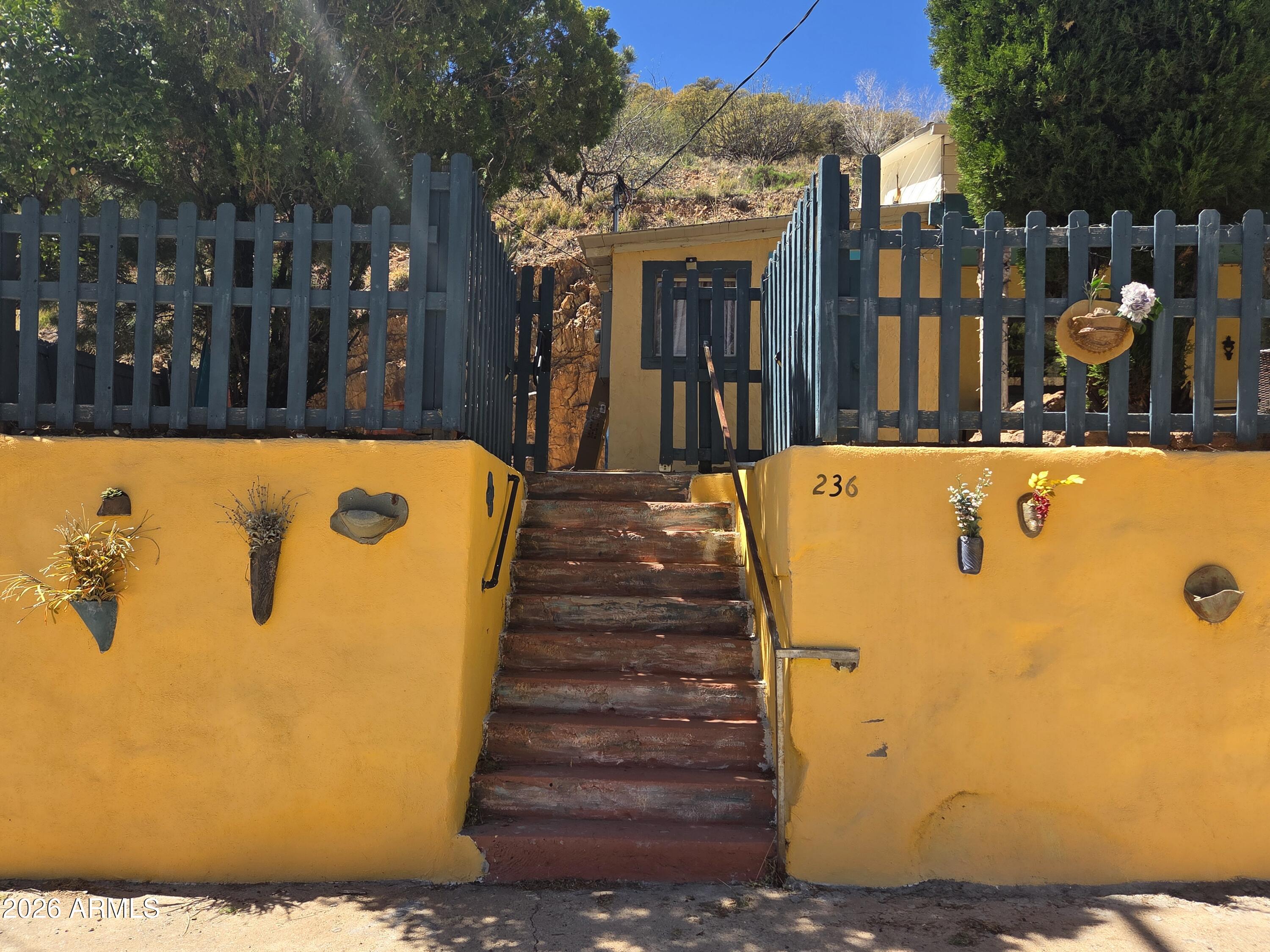 A Santa Fe feel in Old Bisbee. 2 Bedrooms, with private baths. One bedroom on each end of the house. Large kitchen, dining and living area are shared in a extended layout. The house has been completely renovated, including newer HVAC, standard hot water and a on-demand hot water heater for one bathroom/laundry. Picture windows display the rock face wall in the backyard. Several entrances to access different areas of the grounds. Level and independent garage also has been updated and has an EV charging station. Private setting, though addressed downtown,  welcoming and peaceful.