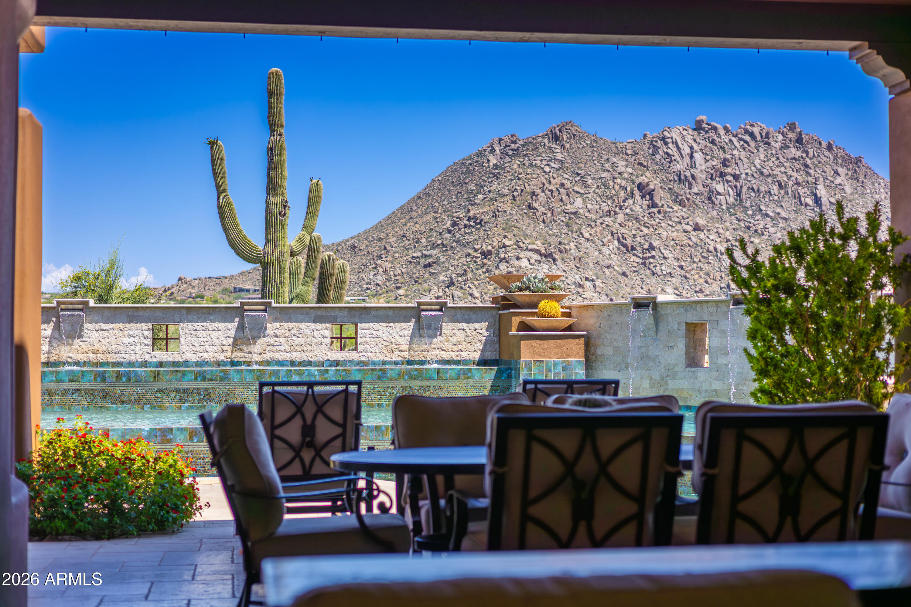 Nestled within the exclusive, gated enclave of Privada at the Four Seasons Resort, this masterpiece seamlessly blends sophisticated design with the ultimate Arizona indoor-outdoor lifestyle. From the moment you arrive, the private front courtyard sets a serene tone with a soothing water feature and an intimate fire pit.
Inside, a motorized pocket door effortlessly disappears, framing jaw-dropping, unobstructed views of Troon Mountain and pristine desert sunsets. The main residence features a highly desirable split floor plan, boasting a grand primary suite oasis, two spacious secondary en-suites, and a versatile flex room perfect for a home office or private fitness studio. Guests will enjoy unparalleled comfort in the attached casita, complete with its own private entrance, a bedroom, full bath, and a dedicated wet bar.
The backyard is an entertainer's paradise reminiscent of a five-star resort. Unwind by the sparkling pool and spa, featuring a swim-up bar, multiple fire pits, and a cozy outdoor fireplace. Host unforgettable gatherings utilizing the premium outdoor kitchen, fully equipped with a built-in BBQ and a teppanyaki grill, all while patio misters keep the desert breeze perfectly cool.
With world-class hiking at Pinnacle Peak and Tom's Thumb just minutes away, and the premier amenities of the Four Seasons at your doorstep, this property offers a rare standard of living in North Scottsdale.