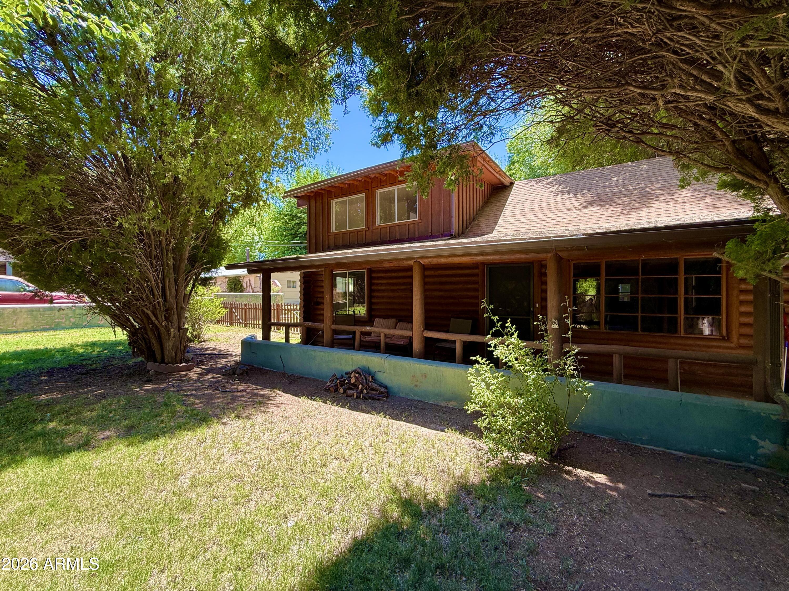 Charming log cabin-style home nestled on a .20-acre lot in the heart of Rimrock, just minutes from Wet Beaver Creek and outdoor recreation. This 3-bedroom, 2-bath home offers the perfect blend of rustic character and modern updates. Step inside to a spacious great room featuring soaring vaulted ceilings, exposed log beams, and a cozy fireplace that creates a warm and inviting atmosphere. The interior has been freshly painted and new flooring throughout the entire home. Both bathrooms have been updated, providing a fresh and modern feel. The private upstairs primary suite offers a peaceful retreat, while the covered front porch and mature shade trees create an ideal setting for relaxing and enjoying the outdoors. This unique property is ready for its next owner!
