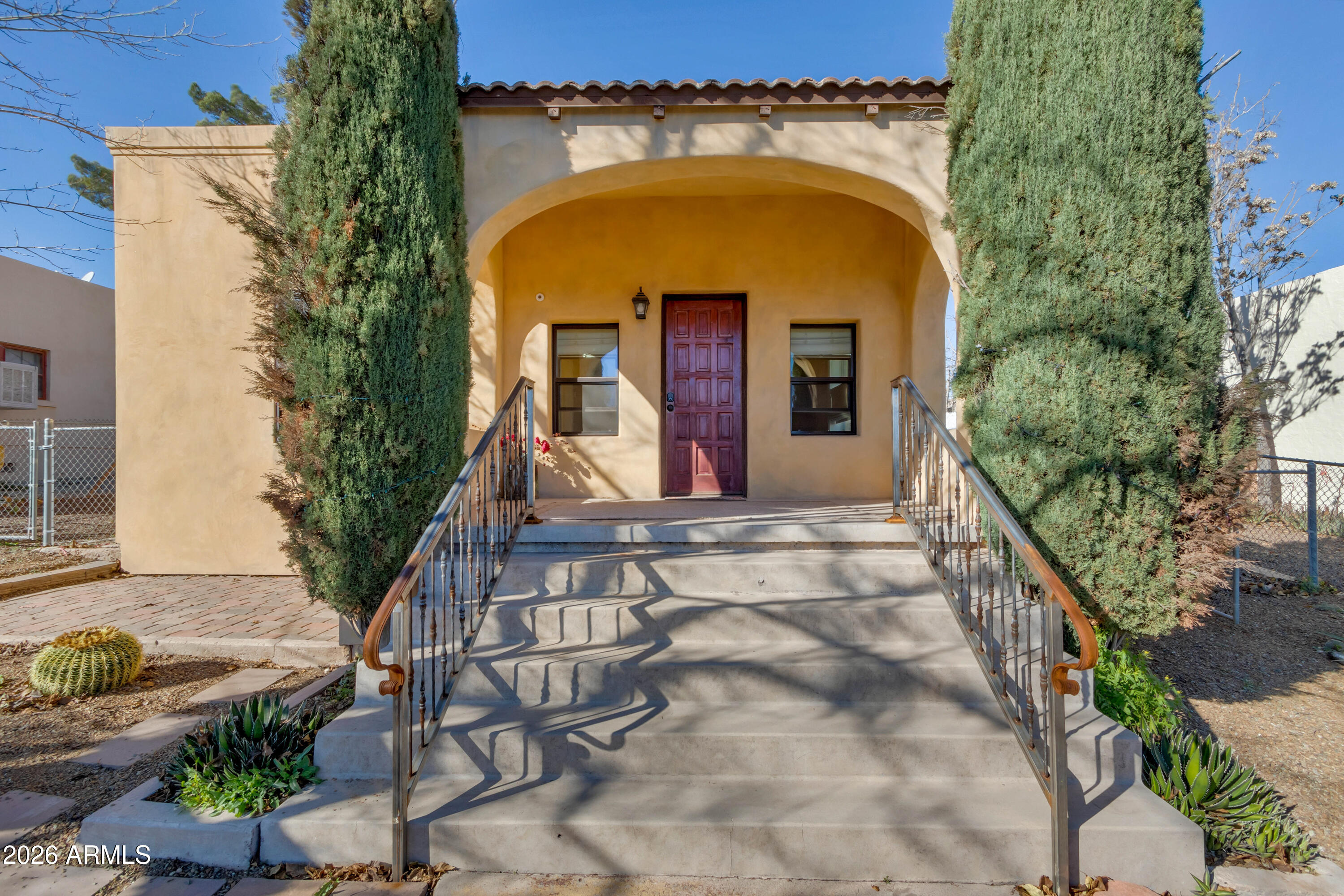 Timeless architecture. Refined upgrades. 

In the heart of Upper Clarkdale, this exquisitely restored Spanish Colonial Revival bungalow offers a rare fusion of preserved heritage and elevated modern living. Thoughtfully reimagined with respect for its historic integrity, this residence delivers character you can feel — paired with the kind of behind-the-walls improvements that make daily life effortless.

From the moment you arrive, the Spanish-style façade and custom iron railings establish a sense of distinction. The covered front porch feels lifted from another era — an idyllic vantage point for morning light, painted sunsets, mountain silhouettes, and the quiet rhythm of birds and wildlife moving through the valley below. Inside, authenticity meets refinement. Original birdseye maple floors, soaring 9-foot ceilings, and preserved historic cabinetry create a warm architectural foundation rarely found in homes of this scale. The interiors feel curated rather than remodeled  every finish chosen to enhance, not erase, the home's story.

The kitchen is a graceful blend of old and new: granite countertops, classic original cabinetry, designer backsplash, white ceramic sink with reverse osmosis system, dishwasher, gas range and microwave vented through the chimney, refrigerator, and stackable washer/dryer  delivering modern function wrapped in timeless charm.

The spa-inspired bath is a showpiece. A cast iron clawfoot tub anchors the space, complemented by artisan tilework, a copper sink set in a Mexican pine vanity, oil-rubbed bronze fixtures, custom lighting & upgraded ventilation. The layout has been thoughtfully reconfigured for comfort and code compliance while preserving period elegance.


Behind the beauty lies substance. Major system upgrades include a meticulously maintained HVAC system, sealed ductwork with expanded conditioned living area, blown-in attic insulation, whole-house PEX plumbing, updated drain lines, whole-house water filtration plus RO system, instant hot water heater, upgraded electrical service with panel and garage subpanel, refined texture finishes, updated lighting, and refinished original maple floors.

The primary suite and walk-in closet feel tailored and serene, featuring tile flooring, cedar paneling, custom window treatment & elevated lighting.

Outdoors, a high-end pergola-covered patio creates a true extension of the home's living space  an elegant outdoor room designed for al fresco dining, evening gatherings, or quiet afternoons in filtered shade. It's private, peaceful, and perfectly suited to Clarkdale's temperate climate and starlit skies.  Enjoy easy care desert botanical landscaping with two  beautifully mature mulberry trees.
The former carport has been enclosed to form a versatile garage with workshop potential and substantial temperature-controlled storage closets. Structural improvements to the garage and alley wall, enhanced drainage, durable steel siding, and a professionally resealed roof further underscore the care invested in this property.

And then there's the lifestyle. A short stroll brings you to downtown for concerts, festivals, restaurants, museums, the library, dancing, and local gathering spots. The Verde River, Old Town Cottonwood & Jerome are just minutes away. Sedona's red rock landscapes are an easy twenty-minute drive.

This is not simply a move-in ready home  it is a meticulously restored historic residence offering architectural soul, modern reliability, and an effortlessly walkable lifestyle in one of the Verde Valley's most beloved communities.

A rare opportunity to own a piece of Clarkdale's history  elevated for today.