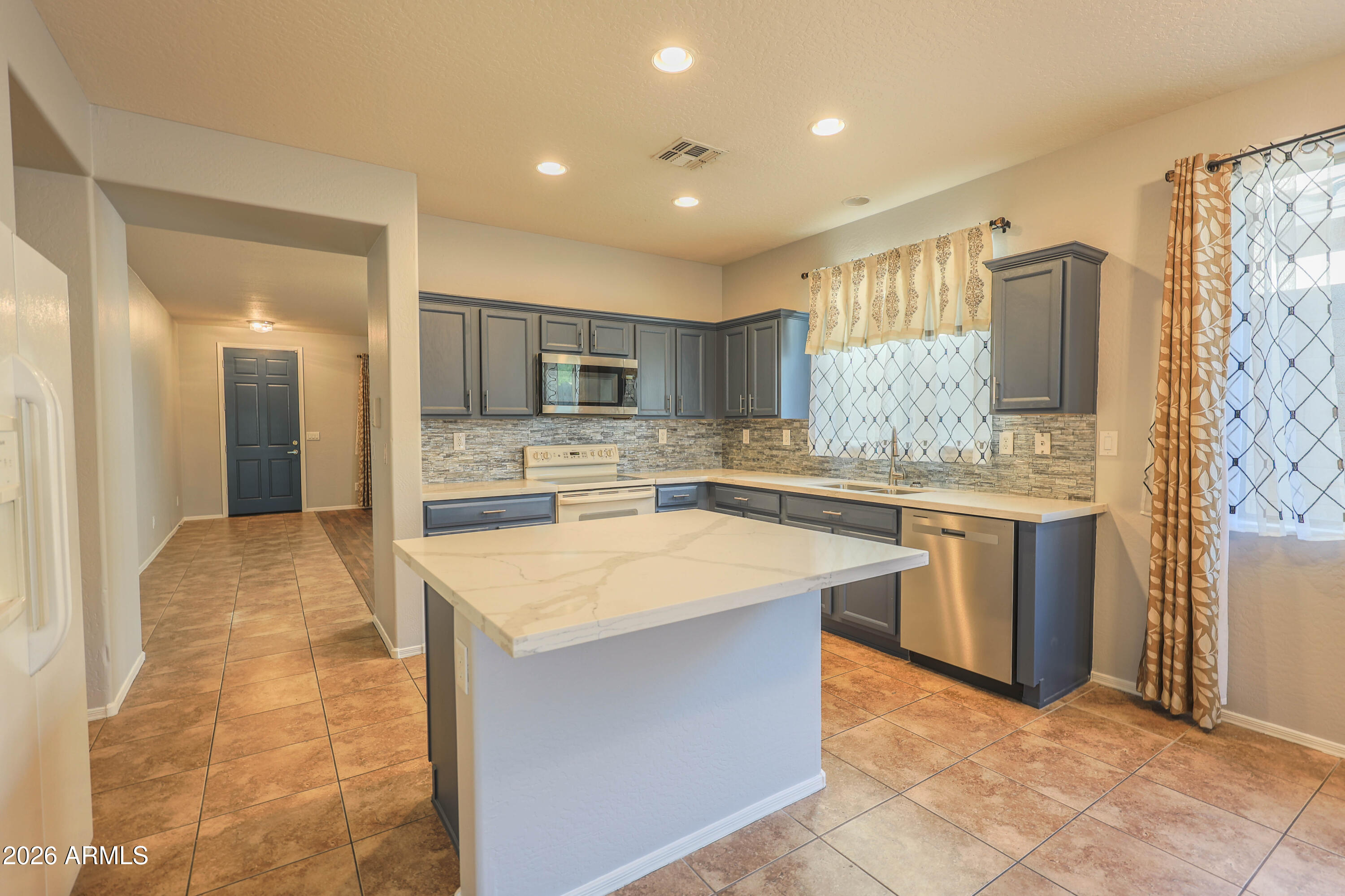 Popular Holiday model with 4 bedrooms, 2 baths, formal living and dining plus family room all on a single level. Just around the corner from shopping, dining and award-winning Gavilan Peak K-8 school. Brand new quartz kitchen counters, floor tile, security doors on front and back patio. Remodeled primary bath with walk-in shower. Included blinds and drapes, soft water system, ceiling fans in all rooms, surround sound, and recently replaced water heater. Peaceful desert backyard and extended patio. Epoxy garage floor with built-in storage cabinets.