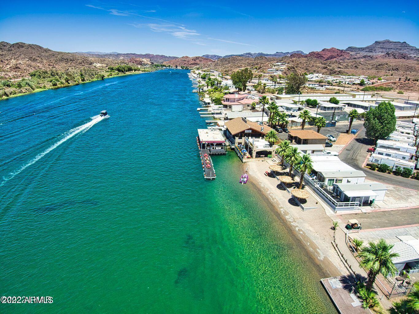 A once-in-a-lifetime opportunity to own a legendary, deeded, fee-simple commercial property on the Parker Strip! A local and tourist favorite! This riverfront, RV/Manufactured home park, & famous floating dock bar & grill can be yours! This 37-space park is on nearly 3 acres and has 217' of water frontage! There are 5 riverfront spaces, over 100' of beach, palapas, docks, & plenty of boat parking. Roadrunner floating dock bar & restaurant have always been a favorite stop on the Parker Strip! It does a tremendous volume, has a class 6 liquor license. The kitchen was recently moved off the dock in a $130,000 remodel. The bar/restaurant is leased & there is a possible opportunity to keep that in place. Continue on without changing anything & the current business pay for itself.