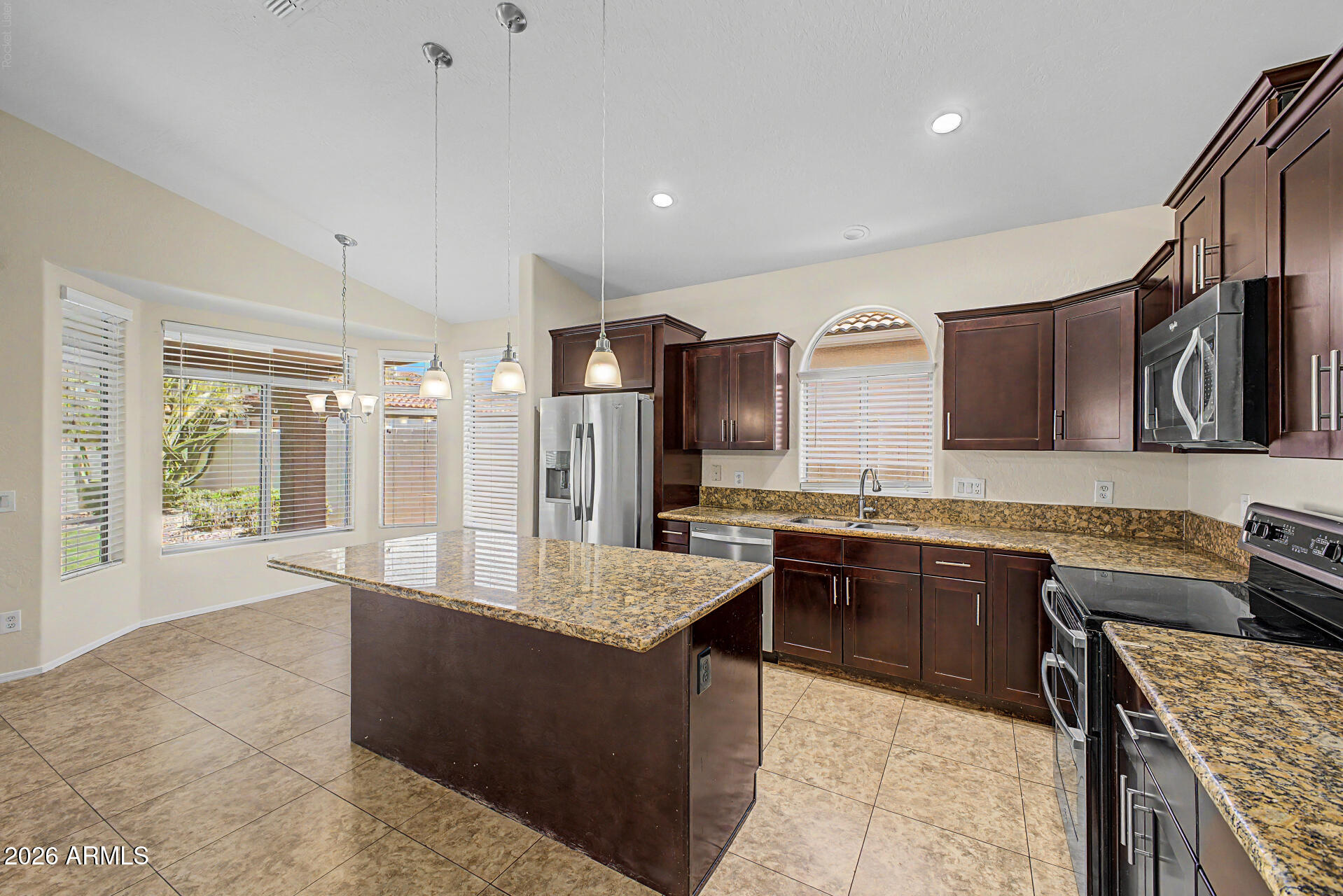 Beautifully maintained single-level home offering 4 bedrooms, 2 bathrooms, and a 2-car garage in the highly desirable Harmon Ranch community! This spacious floor plan features vaulted ceilings and an open-concept kitchen that flows seamlessly into the family room, creating the perfect space for everyday living and entertaining. The beautifully remodeled kitchen showcases modern dark mahogany shaker cabinetry, granite countertops, a center island, stainless steel appliances, and abundant cabinet space. The oversized primary suite provides a relaxing retreat with a large walk-in closet and an ensuite bathroom featuring dual sinks, a soaking tub, and a separate walk-in shower. Three additional bedrooms offer flexibility for family, guests, or a home office. Tile flooring throughout the main traffic areas, new carpet, fresh interior paint, a new water heater, north/south exposure, and lush, mature landscaping in both the front and backyard add to this home's appeal. Ideally located within walking distance of Intel, Desert Breeze Park, and the neighborhood elementary school, with convenient access to shopping, dining, entertainment, major freeways, and everything that makes Chandler one of the Valley's most sought-after communities.