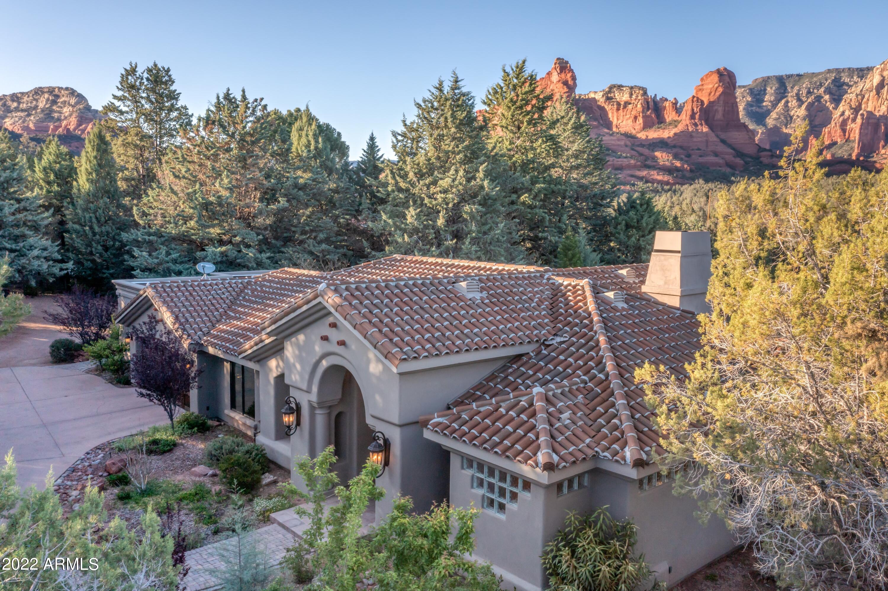 Incredible opportunity! This unique property has best unobstructed views in all of west Sedona! Sits on 1.46ac bordering the Coconino National Forest. Gated entry, VERY PRIVATE fully fenced and elevated lot, yet access to the hiking biking walking trails from your backyard. Main house has 3 bedrooms, 20ft vaulted ceilings with huge windows to capture the views. New 12ft iron and glass front door. Views from every room! Separate guest casita with kitchenette, living room, fireplace bedroom, bathroom & laundry/storage room could be turned into 2nd bedroom.ALSO, guest suite with separate entry, bedroom/living room, wet bar/ beverage refrig, LUX bath completed 2021. Many outdoor spaces to enjoy, large grassy lawn, sand area for games and viewing deck, lower flagstone patio with fire pit.
