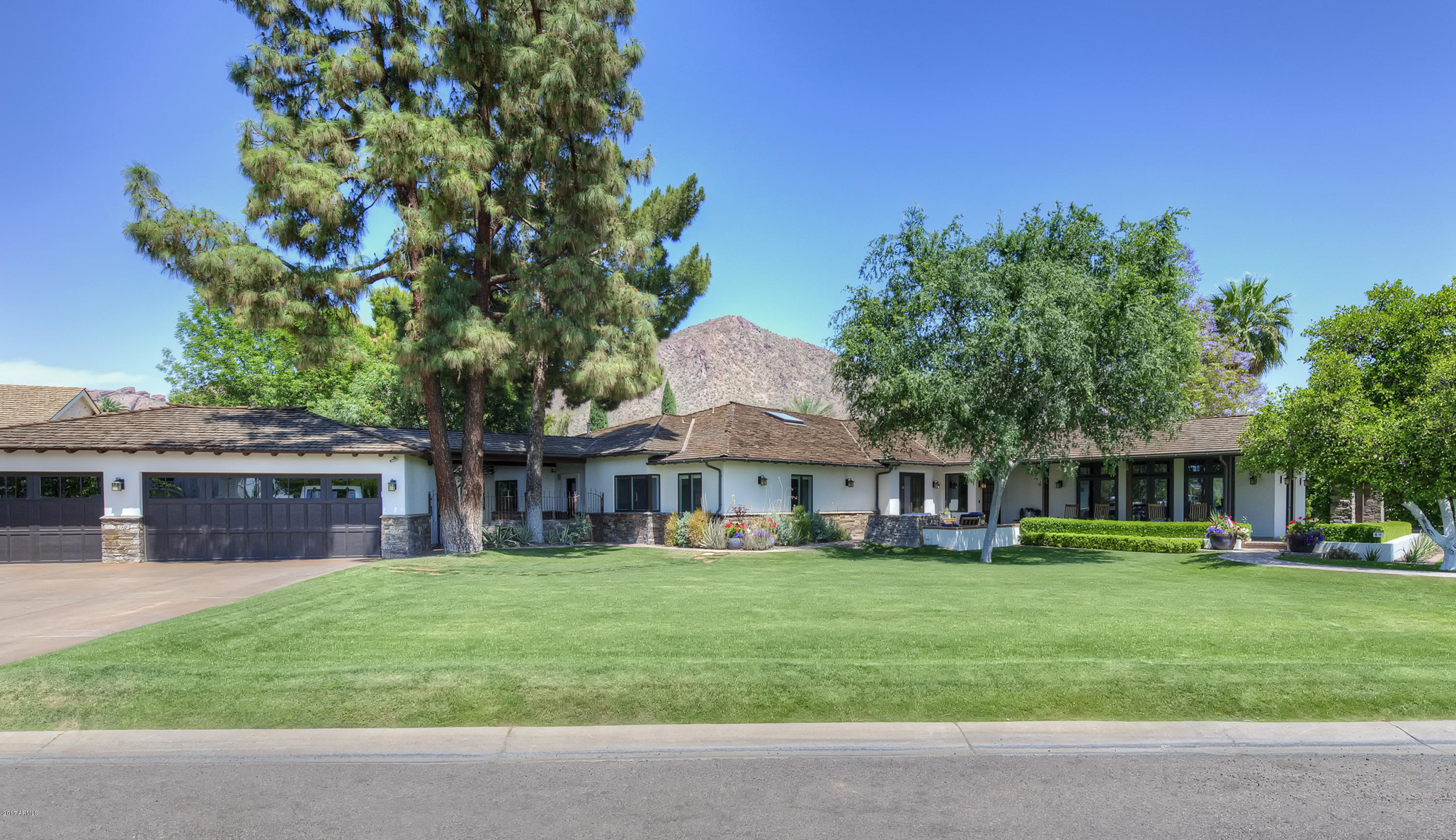 This stunning custom home is full of incredible style! As you stroll from room to room you’ll be struck by the attention to detail and extraordinary design quality. The dream kitchen has every imaginable culinary amenity, the great room is an absolute showpiece with exquisite millwork, an impressive stone fireplace, and gorgeous picture windows that perfectly frame the magnificent outdoor scene. The phenomenal office has its own private entrance, the exercise room is another fantastic bonus, and every bedroom and bath is simply beautiful, including an elegant master retreat.  Custom furniture grade cabinetry, artistic stone, dramatic ceiling details, brilliant lighting and meticulous wood flooring just begin to tell the story of the captivating and creative design elements. The breathtaking grounds include numerous entertaining patios, a large ramada, full outdoor kitchen, and amazing resort style pool and spa creating a truly lavish environment set beneath impeccable camelback mountain views. This luxurious residence is very special and has everything a family could dream of inside and out!