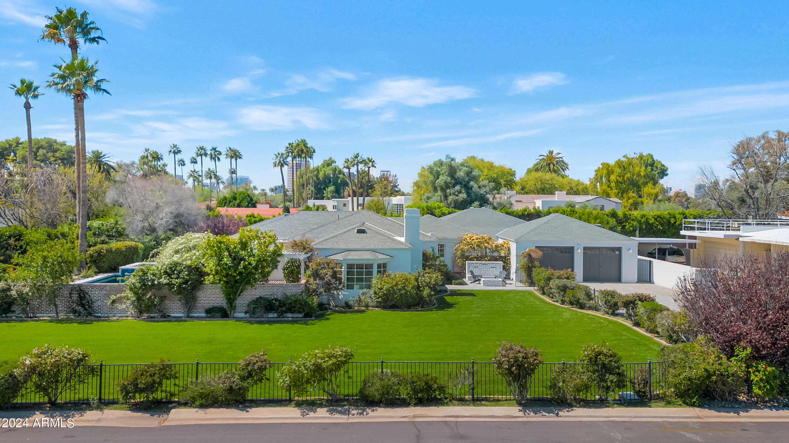 This gorgeous custom home is nestled in the highly coveted Country Club Manor Neighborhood at the Phoenix Country Club.  Upon your arrival, you will be greeted with magnificent curb appeal and stunning rose gardens that surround the property.  As you enter the home, you will be welcomed by the incredible wood beam ceilings that are featured throughout the home, hardwood floors, and beautiful French doors out to the lush resort-style backyard and pool.  The living room and dining room open up to an enormous chef's kitchen featuring top-of-the-line La Cornue, Wolf, and Subzero appliances, marble countertops, and designer details.  The kitchen has French doors opening up to its own courtyard with multiple seating areas, a fireplace, and a vegetable garden. The south bedroom wing offers spacious bedrooms and beautifully designed bathrooms.  The generous primary suite includes its own office space, private access to a patio with a fireplace, dual vanities with marble bathroom countertops & storage, an oversized shower, a separate bathtub, and a walk-in closet.

Separately, the north wing of the house has an enormous laundry room with double washers/dryers and a bedroom/office space with an ensuite bathroom.  You will also find a large space with glass roll-up doors perfect for a family room, game room, or gym.  

With gorgeous design elements and terrific interior/exterior spaces, this house is truly one of a kind and makes for fabulous entertaining.