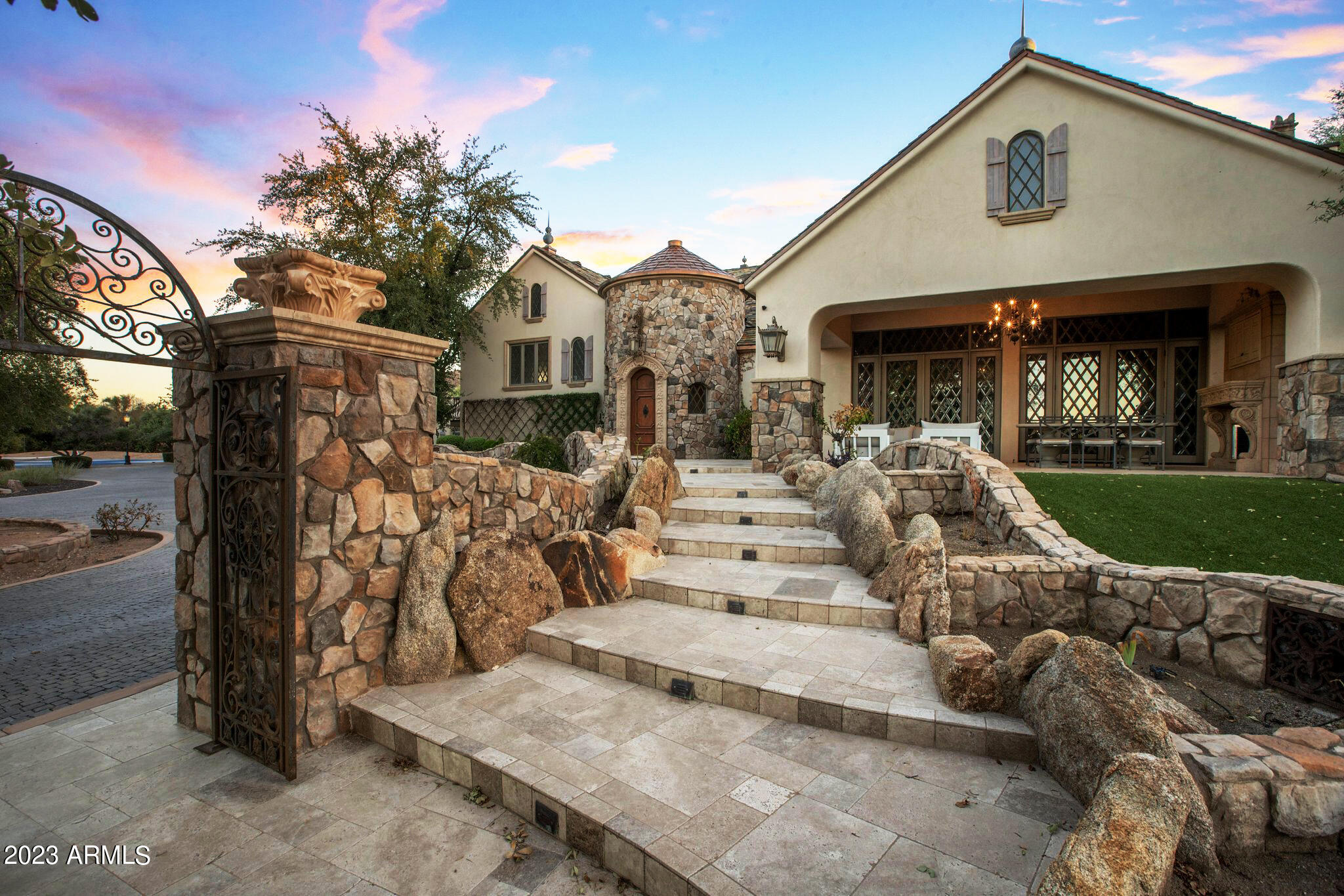 Here is your opportunity for a remodeled French Country Estate with majestic Mummy Mountain views - or - live in this house while building your custom dream home on the estate's 4.3 acre lot. This exquisite home estate boasts unique and rare finishes from around the world, including a Spanish iron front gate, English fence post staircase, New Orleans gas lanterns and slate roof. The hand carved marble fireplaces, solid oak and marble flooring, custom ceilings and beveled glass windows all add to the enchantment of  the home. The main home features 4 bedrooms, 3.5 bathrooms, workout room, media/bonus room, oversized kitchen and plenty of entertaining spaces. The guest house features 2 bedrooms, a full kitchen and separate laundry. The cottage house is connects to the stable and features... 2 bedrooms, 2 bathrooms, full kitchen, laundry, plenty of storage opportunities. The remarkable grounds are the perfect canvas to create your ideal surroundings. The expansive property also showcases a baseball field, 2 tee golf course, children playground area, basketball court and abundance of on site parking.