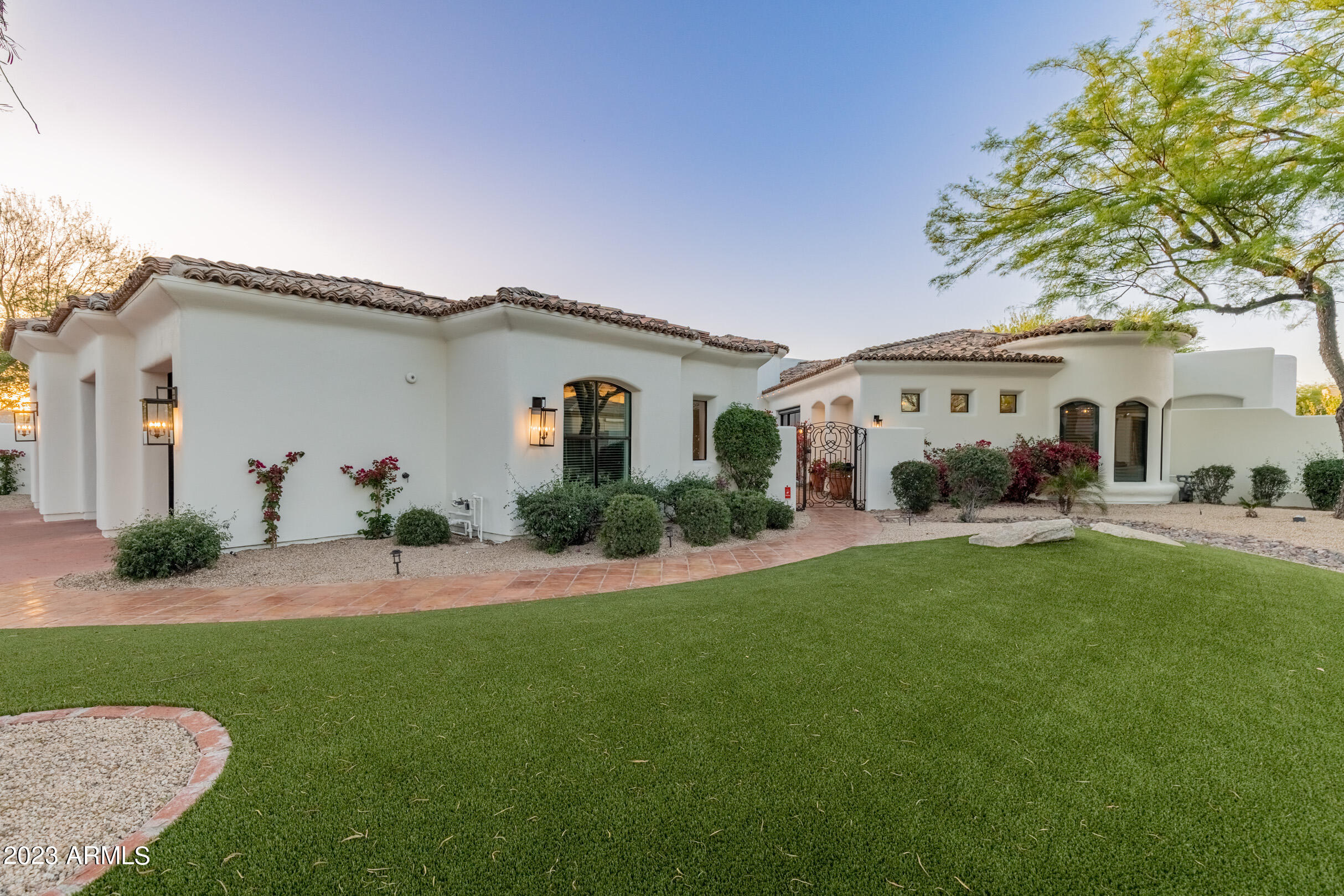 2023 completely renovated, jaw-dropping cactus corridor gem set in a quiet cul-de-sac of a private gated community. This luxurious renovated estate, with customized and quality finishes throughout, leads in with a courtyard entrance inviting you into the transitional modern interior. All single level, with grand rooms and high ceilings throughout, the 4,560 sq ft home feels even larger. The natural lighting, split floor plan and three gas fireplaces adds to the allure of the home. The breathtaking kitchen is filled with stunning custom lighting and brand new high-end appliances. The dual oven/stove, built-in microwave and warming drawer are all Wolf appliances. The perfect kitchen for hosting and cooking beautiful meals also features custom pot filler and hood, large built-in KitchenAid re frigerator, plenty of cabinetry, large walk-in pantry, and a stunning quartz center island. Light oak hardwood floors and 6 inch baseboards throughout. Spacious primary suite with a sitting area, fireplace and private patio. Primary bathroom suite features dual sinks and vanities, a soaking tub and a gorgeous shower. Additionally, the primary has two walk-in closets and another sitting area which can be used as a home gym. Spectacular home office opens to the interior courtyard. Automated blinds. Stunning backyard with remodeled pool and hot tub, built-in Viking BBQ, mister system, and covered patio. The oversized 3 car garage with storage closets and epoxy flooring. RV gate. The half-acre homesite sits in the exclusive Alamosa Estates gated community of just 21 estate homes. Just minutes from the 101 and less than 10 minutes to Scottsdale HonorHealth and the Mayo Clinic. Home is located in a prime location with shopping, hiking & bike trails, and all that Scottsdale has to offer!