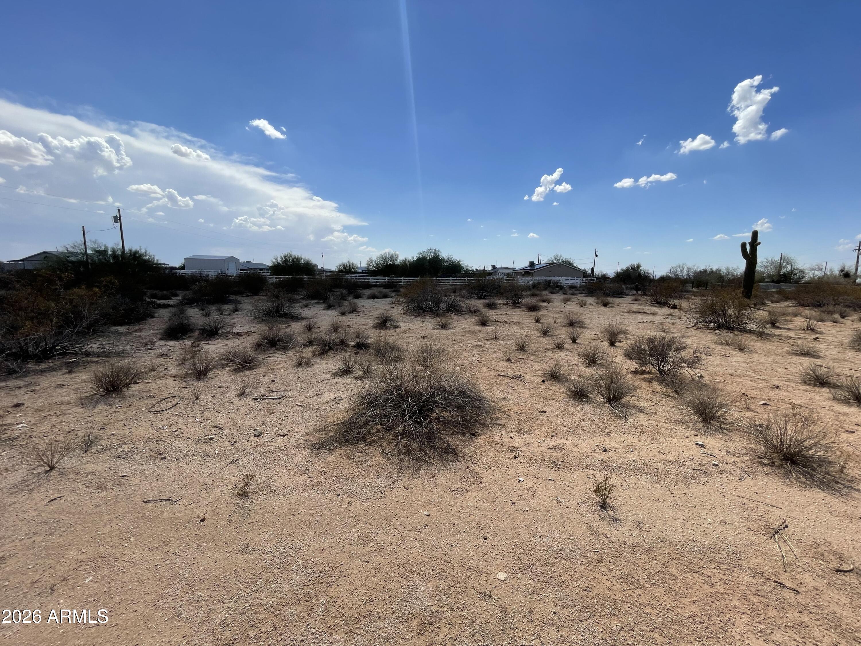Beautiful 1.25-acre parcel offering the perfect combination of privacy, convenience, and classic Arizona desert beauty. This flat, usable lot features four mature saguaro cacti, creating a stunning natural landscape and an ideal setting for your future home. A shared water well is already in place, and electricity is located right next to the property, helping make development easier. Surrounded by neighboring properties yet thoughtfully situated to provide a private feel, this land offers the best of both worlds. Enjoy wide-open desert views, peaceful surroundings, and plenty of space for a custom home, workshop, or outdoor living area. An added bonus: the home next door is also available for purchase, providing the opportunity to expand your property with an additional 1.25 acres.