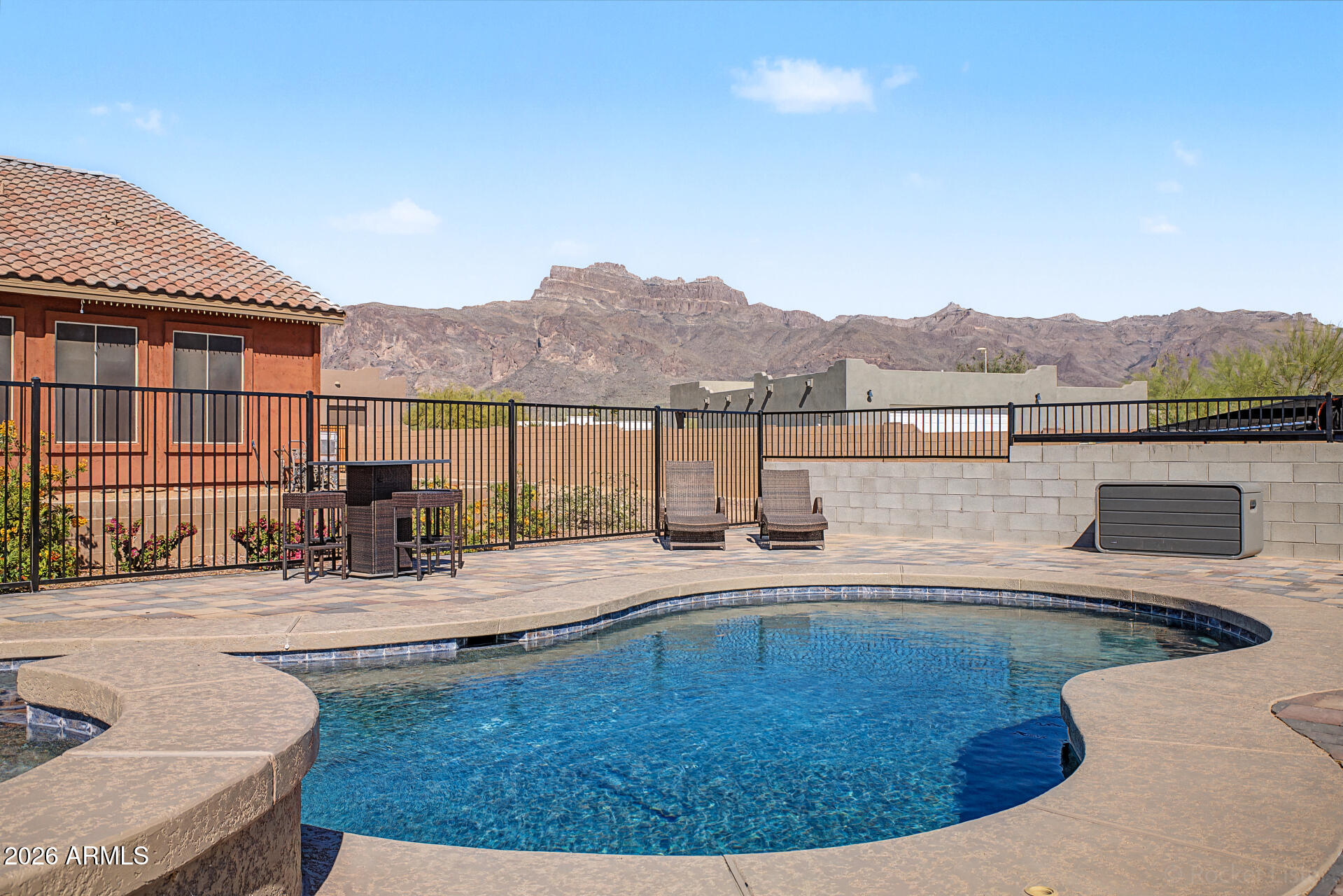 Set at the base of the Superstition Mountains, this stunning custom home is
perfect for multigenerational living. The split floor plan offers 4 bedrooms and 3 baths, including a private suite with its own living area, bedroom, and bath that is ideal for family or guests. The primary suite is a serene retreat with a large bathroom and generous closet
spaces. The upgraded kitchen flows into a spacious living room, with panoramic glass doors opening to an extended patio and heated pool/spa with breathtaking mountain views! This home is made for entertaining!
Two RV gates provide easy access, and the property allows for up to 1,800 sqft of additional build potential, giving buyers endless possibilities to create the space they imagine, offering multiple ways to customize your dream retreat. Home features a premium solar energy package designed for efficiency and long-term
savings. System includes high-performance panels professionally installed to maximize
production and reduce monthly utility costs. Thoughtfully integrated into the home's design
for clean curb appeal and optimal functionality. Existing solar loan to be satisfied by seller
at closing contingent upon acceptable purchase terms.

This is a residence defined by intentional upgrades. Not just aesthetic, but structural,
mechanical, and experiential. From the enlarged outdoor living spaces to the spa-level
baths and zoned climate control, every enhancement reflects a commitment to elevated
design and enduring quality