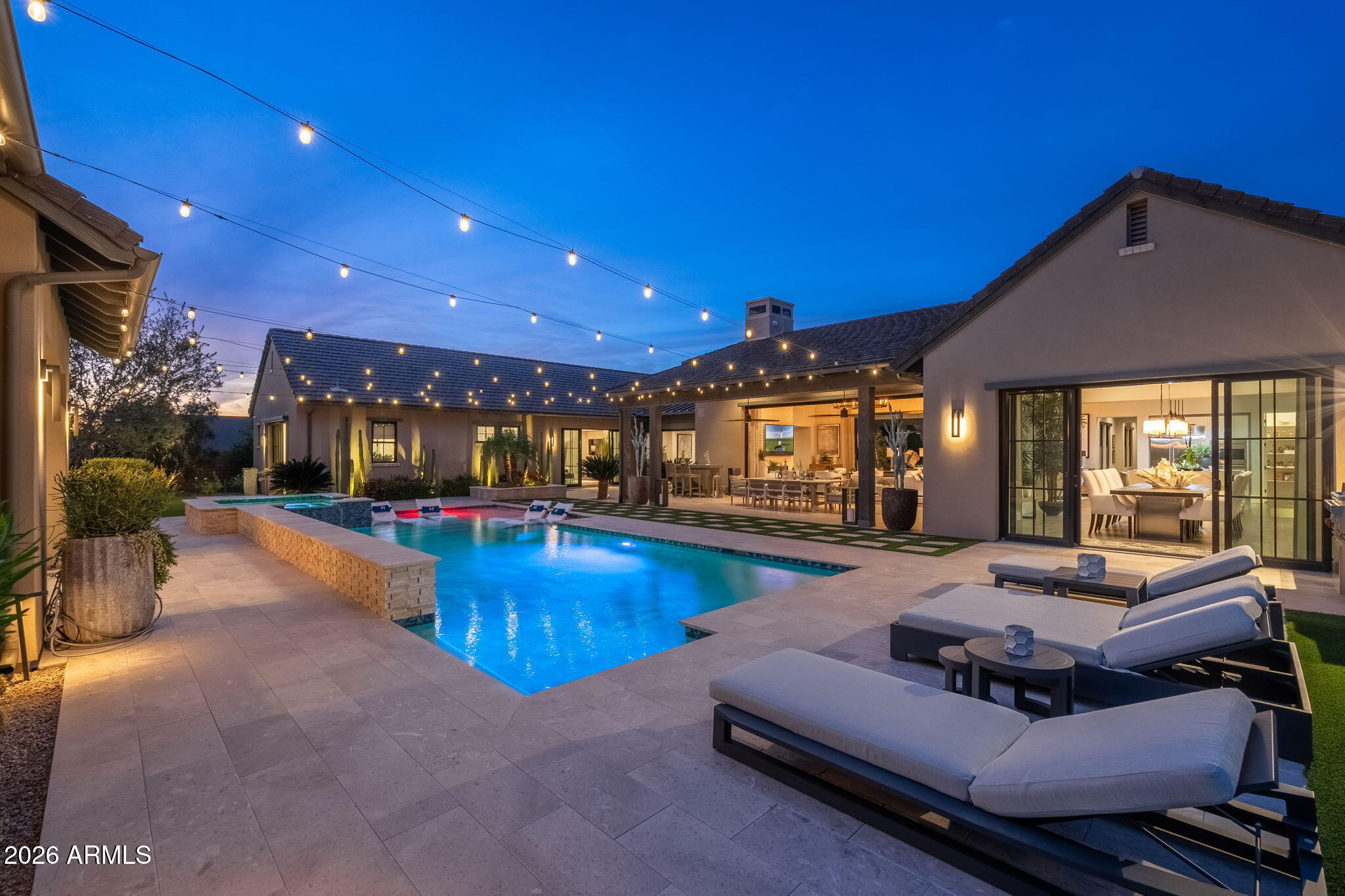 Prime North Scottsdale luxury in the gated community of White Horse. This exceptional single-level Camelot residence offers award-winning contemporary design, seamless indoor-outdoor living, and a private setting with mountain views just minutes from premier golf, dining, shopping, and hiking. Thoughtfully upgraded with Restoration Hardware finishes, dramatic designer lighting, enhanced AV/sound/security, and retractable glass walls that open to a stunning courtyard and resort-style backyard, this home was built for both elevated entertaining and effortless everyday living. The flexible layout includes a pool house ideal for guests or multigenerational living, plus a separate casita with its own kitchen, living area, and full bath.
The chef's kitchen is a showpiece with Wolf and Sub-Zero appliances, dual dishwashers, walk-in pantry, striking wine wall, and Quartzite waterfall island. All five guest bedrooms are ensuite, and the private primary suite delivers a true retreat with spa-like bath, oversized closet, and direct outdoor access.
A rare opportunity to own one of North Scottsdale's most compelling single-level luxury homes.