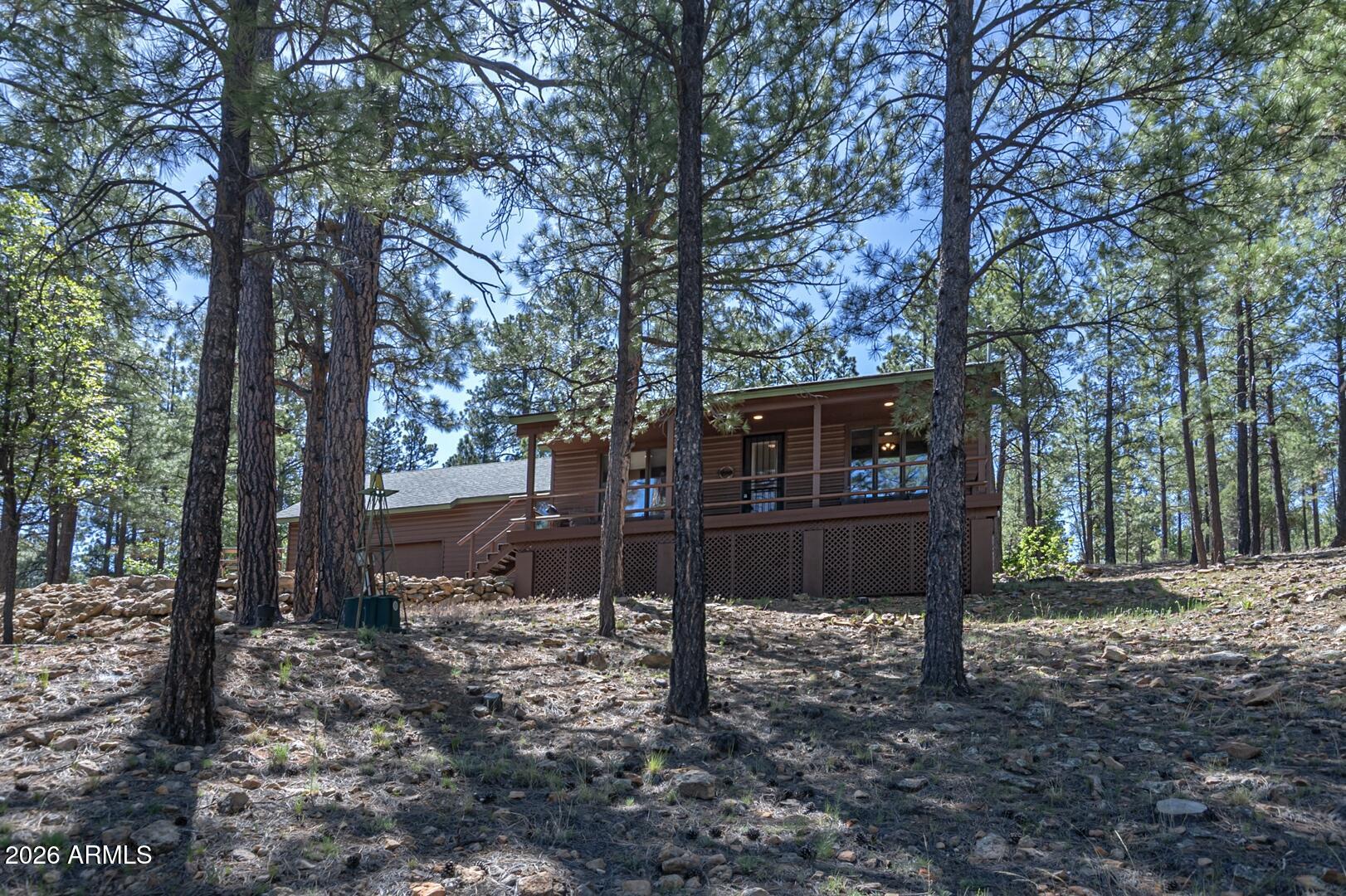 Escape to the cool pines of Happy Jack in this charming mountain cabin located on a beautifully treed 1.08-acre lot in the desirable Starlight Pines community. With year-round access on county-maintained roads, this well-maintained retreat offers the perfect blend of comfort, privacy, and outdoor adventure. Inside, you'll love the rustic charm featuring tongue-and-groove vaulted ceilings, rich wood accents, and a spacious great room with a cozy wood-burning stove. The thoughtful floor plan includes two private master suites, ideal for hosting family and guests. Step outside to a large covered deck surrounded by towering pines and fresh mountain air--perfect for relaxing, entertaining, or stargazing. An attached two-car garage provides ample room for vehicles, toys, and outdoor gear. Horses are allowed, and nearby fishing, hiking, trail riding, and wildlife make this an exceptional full-time home or weekend getaway in Northern Arizona.