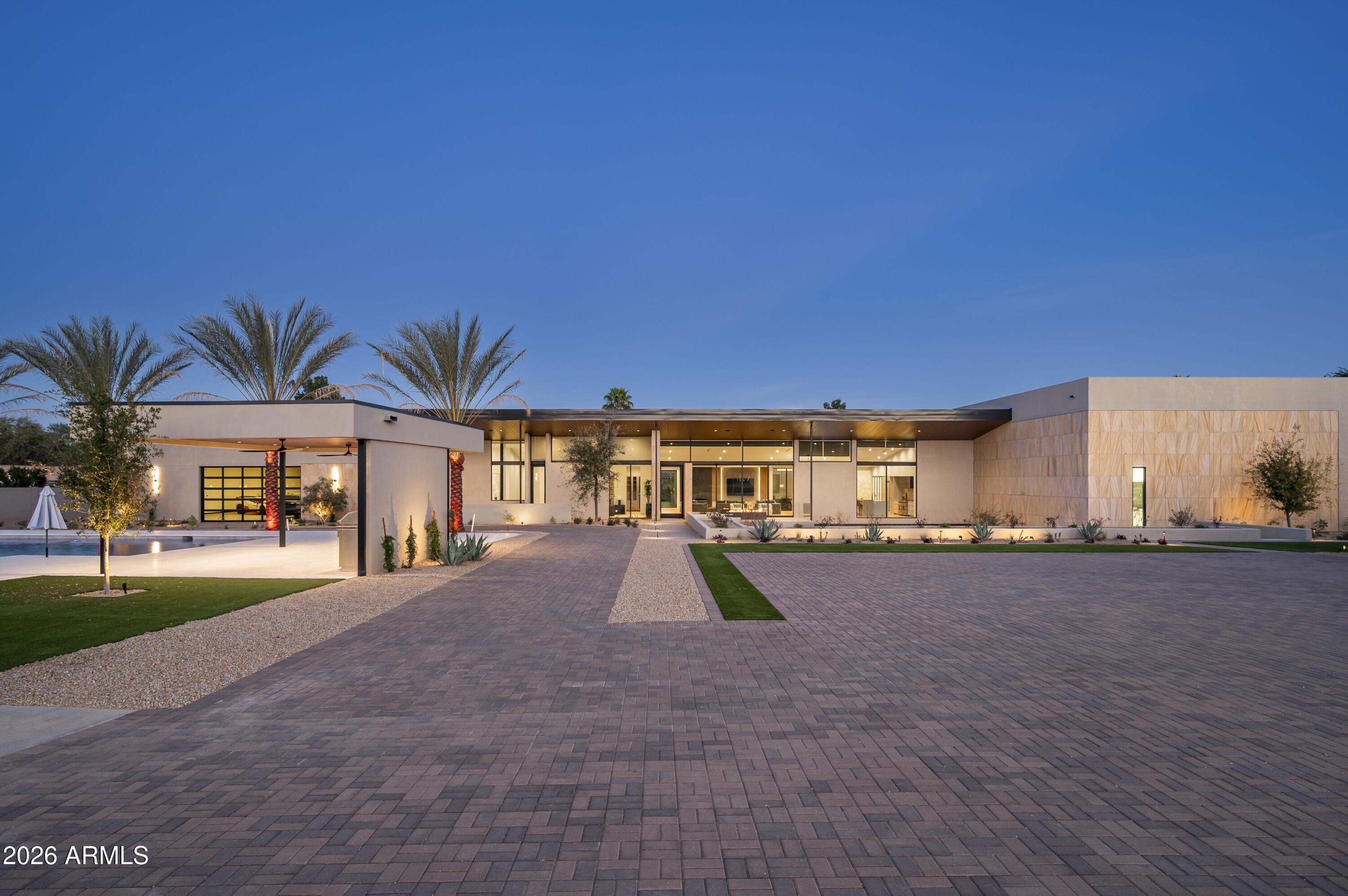 An Estate Beyond Comparison! Designed to Redefine Scale & Set the Standard for Private Luxury!
This is a fully gated statement estate set on just under 2.25 acres is designed for scale, privacy, and experience. Inside, you'll see professional-level amenities you rarely find in a private residence, including a full indoor basketball arena, a three-lane shooting range, a two-lane bowling alley, a 12-seat Dolby theater, a golf simulator, a wellness center with sauna, steam room, and cold plunge, and parking for up to 50 vehicles. The home is fully automated, built for entertaining at the highest level, and every space is intentional. This is one of those properties where photos don't prepare you, each room reveals something unexpected. Passing through the private gates a grand pavered drive curves through lush landscaping with ample space for guest parking. As you walk up to the home, a glimpse of the lower-level courtyard comes into full view where cascading water quietly hints that this home is anything but ordinary.
The front is dominated by a full wall of glass, including the main door and collapsing doors, offering a preview of the inside. Crossing the threshold, you enter the great room with tall vaulted ceilings, the soaring space is anchored by a floor-to-ceiling marble fireplace, open to both kitchen and dining. A small atrium graces the front of the dining area, allowing natural light to flow. There is a relaxing balcony off the great room for taking in the gorgeous mountain views.
The kitchen is designed to impress. Dual side-by-side islands provide both scale and functionality, while a 60' Bluestar with double oven range and dedicated meat locker ensure culinary performance at any level. Backlit glass cabinetry adds a subtle glow, combining sleek modernity with warmth. Hidden just beyond, a butler's pantry/catering kitchen expands with a full industrial-style walk-in fridge and freezer, to complete functionality there is a 48" Bluestar range with charbroiler, Bluestar double ovens, multiple Wolf warming drawers, Wolf vacuum sealer, Scotsman gourmet cube ice maker and Scotsman nugget ice maker and vent hood, perfect for large-scale entertaining or private chef experience. Of the kitchen the is a wet bar helping to make entertaining a breeze. 
Following the hallway from the wet bar, you can enter the indoor basketball court,a full-size, professional-level arena with gleaming hardwood floors, soaring ceilings, and stadium-style lighting that makes it feel like a pro stadium. The walls are fully padded for safety, and a built-in surround sound system brings every bounce, whistle, and cheer to life. Off the court, a door leads directly to the wellness center, a complete recovery space featuring a red-light sauna, steam room, and cold plunge.
From the same hallway that leads to the basketball arena, beautifully-lit stairs descend to the basement, where the space truly comes alive. A three-lane shooting range awaits, complete with a hospital-grade air purifier, making it safe, clean, and even convertible into a cigar lounge. The range offers abundant storage and display space for firearms, all protected behind a bulletproof door cleverly hidden behind a wall that looks completely ordinary, access is entirely hidden.
The basement also features a fully equipped two-lane bowling alley, complete with automatic ball return a machine that cleans and oils the lanes, dual screens above the lanes, and ample seating, recreating the experience of a commercial bowling alley with a more comfortable, private luxury feel. Additionally there is a shark tank, a golf simulator which also has a competitive shooting/hunting game with rifle and pistol included, and a storage locker stocked with bowling shoes in every size, from toddler to professional athlete. The 12-seat theater room delivers a true cinematic experience with Dolby surround sound. A full basement wet bar serves all of these spaces, featuring two sinks, dual beverage/wine refrigerators, abundant cabinet storage, and a dishwasher, perfect for hosting friends, family, or large-scale events. From here, A pool table sits right in front of the walkout that leads to a stunning courtyard, which offers a covered patio, with two firepits, and a massive 135-inch pixel TV, making it ideal for outdoor movie nights, sports, or entertaining on a grand scale.
Back on the main level, the home continues to impress with a private office that includes a full bank-vault safe room. This is a true professional-grade vault 100 year old, built with thick steel and serious security,an incredible and unexpected feature. The main residence also offers five guest bedrooms, each with its own ensuite bathroom and walk-in closet. There is a dedicated laundry room that features a dog washing station, utility sink, custom cabinetry throughout, a built-in garment steamer, and two washers and two dryers. Throughout the residence, three thoughtfully designed powder rooms are placed for guest use, each finished with the same attention to detail seen throughout the home.
The primary suite brings the experience back to extraordinary. Entry is made through a massive pivot door that spans the entire wall, transforming what would normally be a wall into a dramatic architectural statement. Inside, a wall of windows frames the space, with a marble fireplace centered perfectly between them. The walk-in closet stretches across the full back wall of the suite and is outfitted with custom cabinetry designed for every type of wardrobe and accessory. It features two separate access points and a stacked washer and dryer for added convenience. The primary bathroom is designed as a private spa. A full steam shower features a rain shower head, dual shower heads, handheld wands, and integrated body jets for a fully immersive experience. A freestanding soaking tub, dual vanities, and two private water closets complete the space. The entire back wall of the bathroom opens through collapsing pocket doors, seamlessly connecting to a private outdoor courtyard with an outdoor shower and hot tub/cold plunge, this is a true resort-level retreat within the home. 
The entire home (including the casita) is powered by a fully integrated smart system, featuring advanced AVA control and Crestron home automation. Lutron lighting is installed throughout, with electronic shades and motorized pocketing glass doors for effortless control of light and privacy. Skylights are thoughtfully placed across the home, enhancing natural light in key spaces. There are over 30+ Freepower phone chargers in the stone slabs, allowing phones to charge simply by placing them on the surface.
Stepping outside, the scale continues with a massive, sparkling pool designed for both relaxation and entertaining. An infinity-edge spa blends seamlessly into the water, while a dramatic grotto adds a resort-style feel. Just off the pool, a raised viewing deck creates the perfect spot for tanning or lounging. Two gazebos anchor the space, one of which includes a built-in TEC gas grill and a wood burning Santa Maria grill, ideal for poolside gatherings.
Separate from the main residence, a detached casita offers exceptional accommodations for guests or extended stays. The casita includes five bedrooms, four and a half bathrooms, and a fully equipped kitchen. A fireplace in the great room, while an additional fireplace adds warmth and comfort to the primary bedroom. A covered patio extends the living space outdoors and opens directly to the seven-hole putting green. 
Privately gated estate just shy of 2.25 acres in Paradise Valley, designed by Just Interiors, this remarkable, one-of-one estate is perfectly positioned at the meeting point of Paradise Valley and Scottsdale, pairing resort-level amenities and absolute privacy with effortless access to the area's most coveted dining, shopping, and lifestyle destinations.