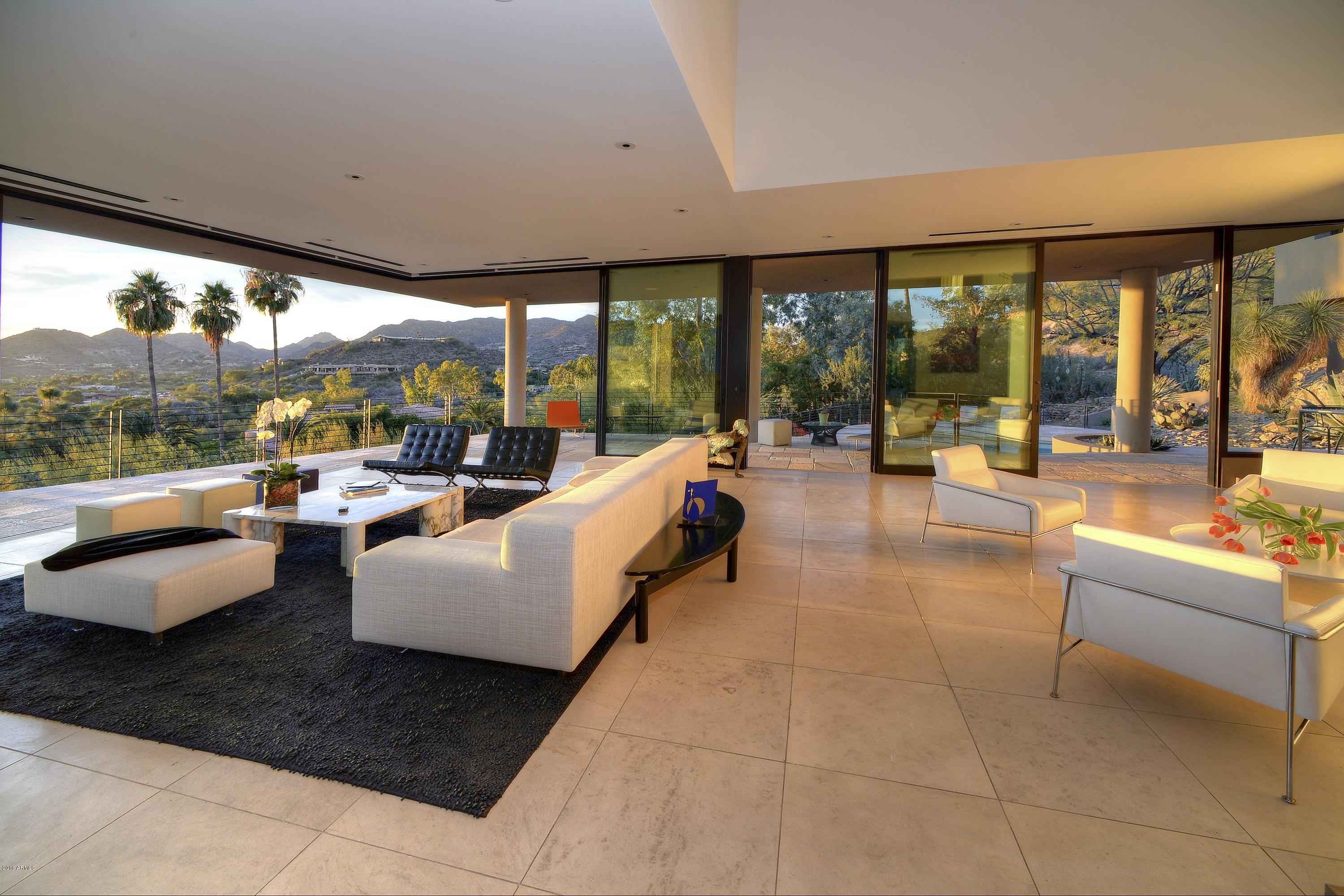 This world class modern home is impeccable in every detail-soaring ceilings, dramatic walls of glass, wide expanses of retractable doors, bright natural light complemented by extensive art and ambient lighting, gourmet bulthaup kitchen, Poliform cabinetry, impeccable materials including French oak and Portuguese limestone flooring. The unique home site provides both privacy and the most spectacular views in Paradise Valley sweeping across Camelback Mtn, the Phoenix skyline, and the Paradise Valley CC golf course and clubhouse. The floorplan is very open and provides endless flexibility for all lifestyles. The detached guest house also provides commanding views. Nestled into Mummy Mountain, this is a low maintenance, lock and leave home. Truly the finest modern property in Paradise Valley!