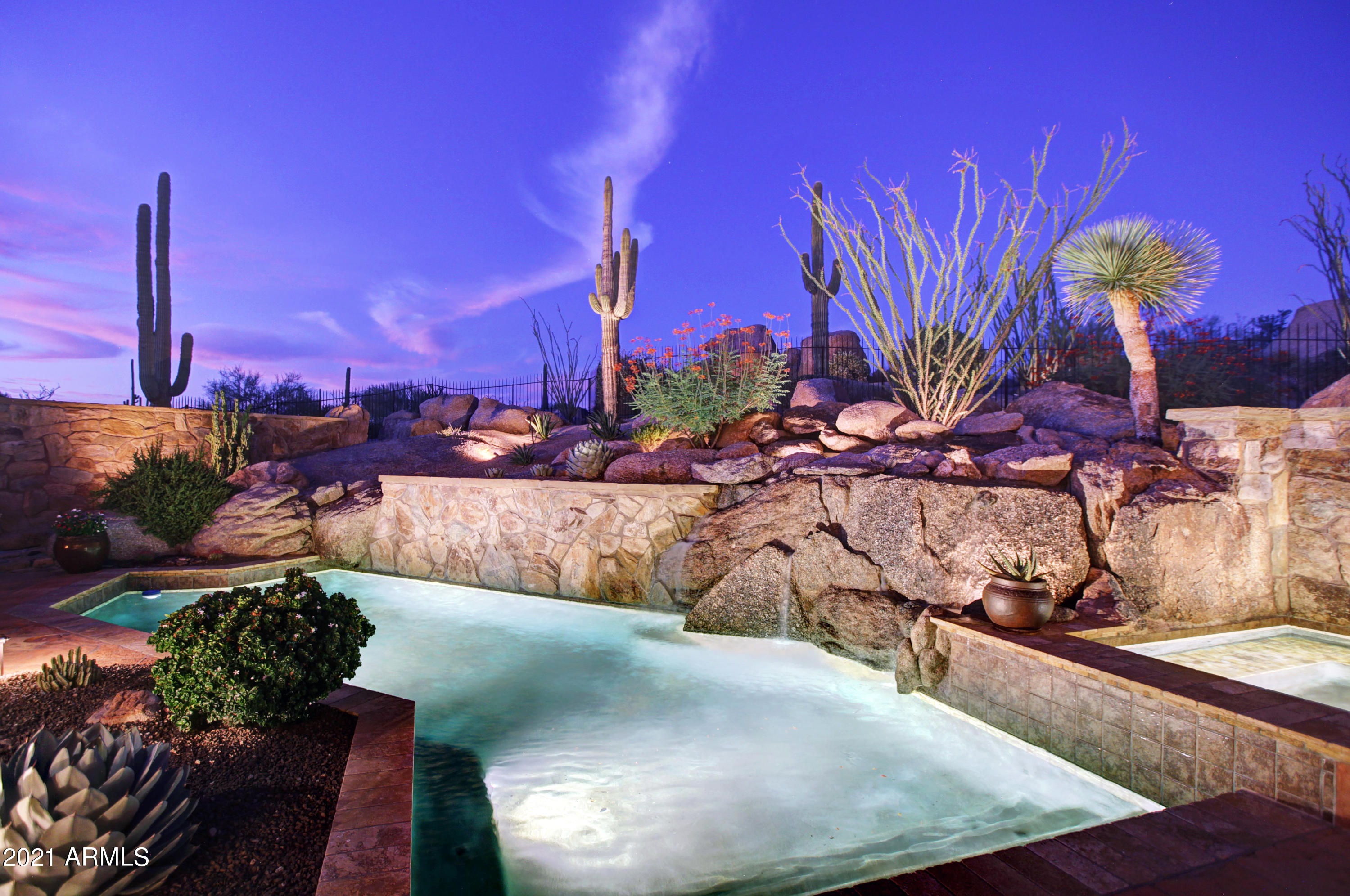 One of the most spectacular custom homes in the exclusive guard-gated community of Estancia. This Sonoran Desert dream home graces the hillside with up close views of Pinnacle Peak. Located between the 3rd and 9th golf holes of the Estancia Golf Club, the sprawling desert dwelling offers architectural details such as hand-hewn beams, box beam and groin vault ceilings, reclaimed oak flooring, natural stone floor and wall accents, and a floor plan designed to entertain. The open concept floor plan is anchored in the kitchen with seamless access to the family room, breakfast area, and the dynamite outdoor spaces. The numerous patio lounge and dining spaces surround the heated pool and spa with rock water fall, built in barbecue, and desert landscapes including majestic saguaros. A private temperature controlled wine room perfect for any wine connoisseur. The master wing includes a full master suite with separate soaking tub, dual vanities, dual walk-in closets, dual water closets, private shower, sitting area, office area, fireplace and private patio. The guest wing features three additional ensuite bedrooms and a full sized laundry with plenty of storage space. The upper level office could be used as fifth guest room and has wonderful views of Pinnacle Peak with a full private bath complete with shower. In addition to the Pinnacle Peak views, the office also has a private patio overlooking the auto court and three oversized garage bays. Five fireplaces throughout including three located in the family room, great room, and master bedroom and two exterior patio fireplaces. Estancia is one of the top communities in North Scottsdale and the Estancia Golf Course is currently rated #1 in the state of Arizona. This elegant private guard-gated golf community, on 640 acres, wraps around the north side of Pinnacle Peak, Scottsdale's famous natural landmark. The Estancia Club is a Tom Fazio signature 18-hole championship golf course, which receives consistent national acclaim. The Estancia Club Memberships are available (Estancia real estate ownership not required) and include tennis, swimming and a fitness center.
