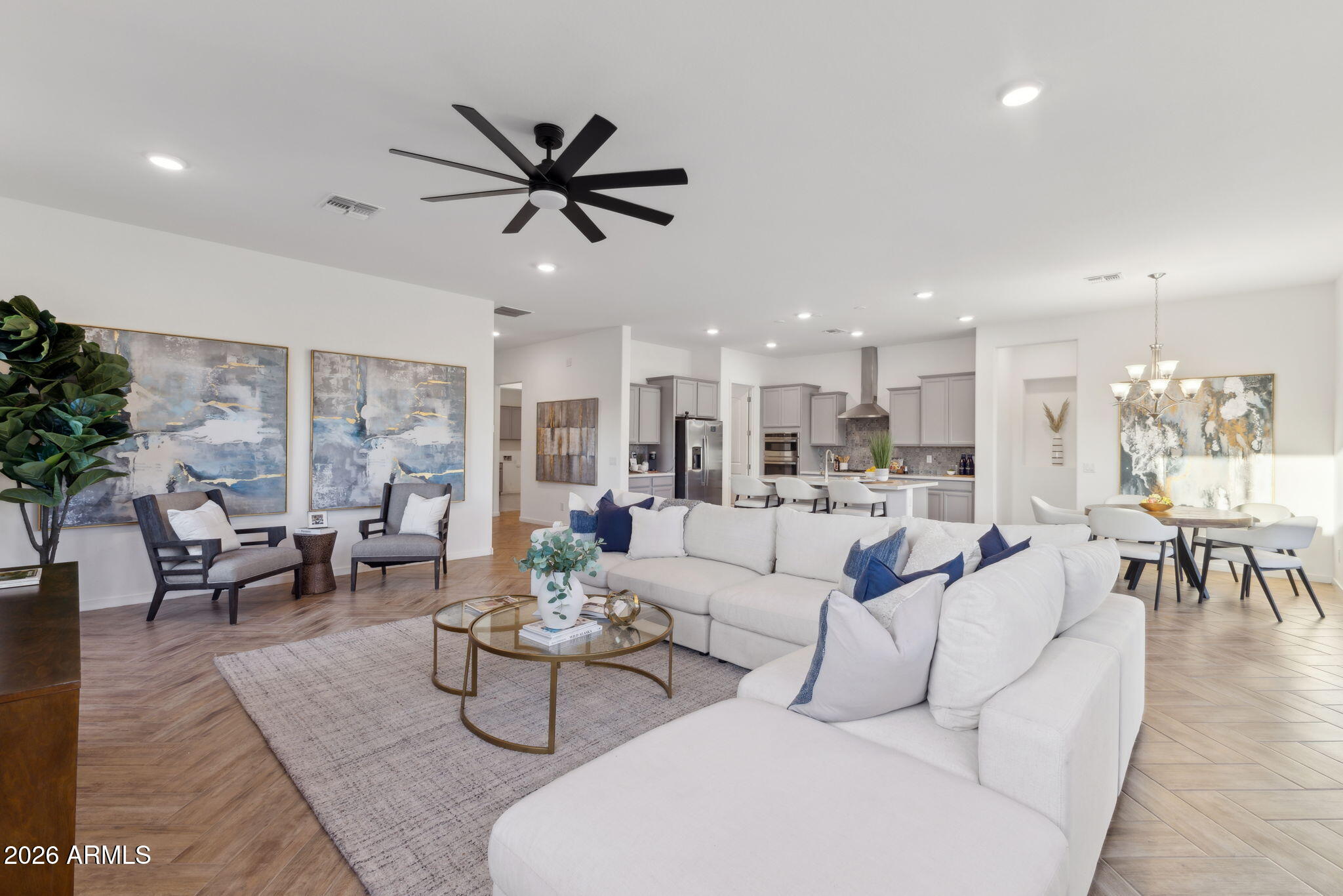 Beautifully upgraded 2023-built home ideally located minutes from Verrado Marketplace, golf, dining, parks, trails, and convenient I-10 access. This move-in ready home offers 3 bedrooms, den, 2.5 baths, and a 3-car tandem garage with an open-concept floor plan featuring 10' ceilings, 8' interior doors, herringbone wood-look tile, custom cabinetry, quartz countertops, stainless appliances, gas cooktop, and designer finishes throughout. Spacious primary suite with dual vanities and walk-in closet. Low-maintenance backyard offers room for a future pool and outdoor entertaining space. Newer construction without the builder wait, ideal for full-time living, lock-and-leave convenience, executive relocation, or long-term rental flexibility in one of the West Valley's fastest-growing areas.