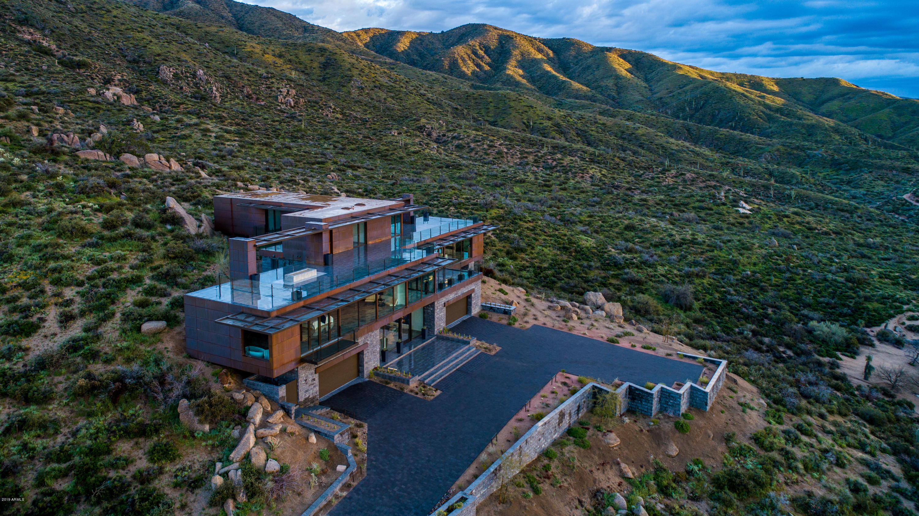 Dramatic New Price for Stunning Contemporary  Masterpiece by Glass Haus. Owner wants this home SOLD! 2018 appraisal of $6.2M. Sleek architecture, lighting and interiors utilizing copper, glass, limestone, tropical woods and dramatic porcelain tiles. Entry level with 4 car garage, gallery reception area, floating staircase & elevator all lead to a grand, open one-level main living featuring a great room w/ perimeter glass walls and bird's eye valley views, large media/family room, resort pool patio, ''floating'' library, and magnificent master suite with luxury spa bath and ''showcase'' closets. Upper level offers 3 ensuite guest bedrooms and  view deck with firepit and dazzling forever views from atop Apache Peak Village.  Floor plans found in Docs tab.
