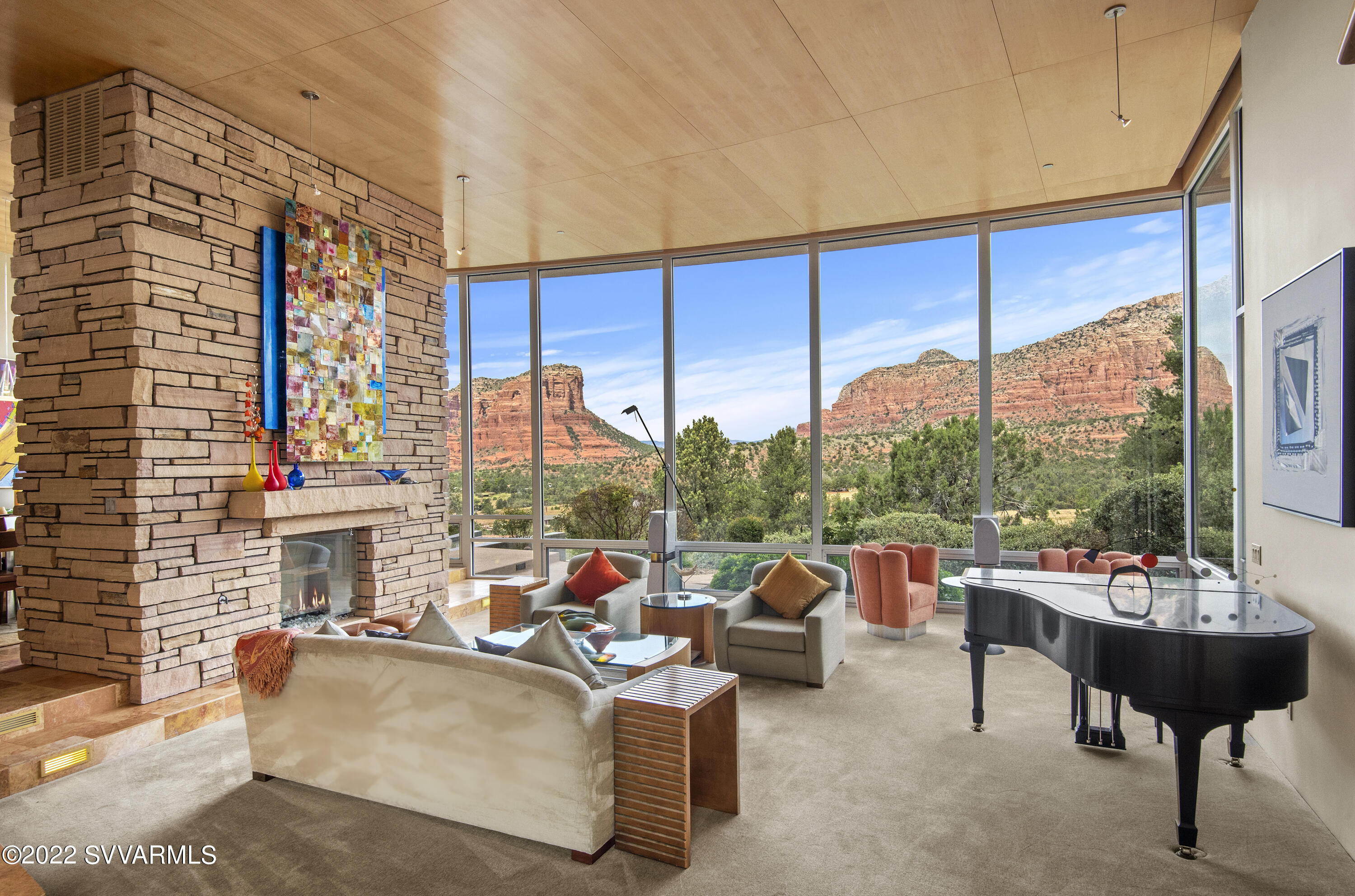 You will delight in this a one-of-a-kind soft contemporary home on just over three acres, capturing elevated panoramic red rock views from its serene hilltop setting. The combination of the renowned Design Group Architects and Joel DeTar Construction produced a wondrous, highly detailed stunning home. The residence was designed using the 
Fibonnaci Math Sequence resulting in a spectacular curved structure that takes the finest advantage of the red rock views. Every room has sweeping jaw-dropping panoramic views of Courthouse Butte, Bell Rock and Lee Mountain. The property is adjacent to US Forest Service land and tops a hill for the ultimate privacy. The main residence and spacious guesthouse circle an inner courtyard that is blissfully restful ... with lovely landscaping including a wisteria-covered patio space. No detail has been overlooked for the comfort of family and friends. The great room is grand with a sweeping ceiling and a glass bed see-through fireplace that divides the great room from the formal dining room. Floor to ceiling windows on both sides of the great room give you not only red rock views but also views to the peaceful inner courtyard. This floods the great room with natural light and a lovely cross-breeze for ideal indoor/outdoor living. Many of the furnishings were also custom-designed by Design Group and built to fit the curve of each room. The kitchen will satisfy any chef - A five-burner Viking Stovetop, double Wolf Oven and a Sub Zero Refrigerator are set among large Verde green granite countertops, with a spacious island with seating for a shared culinary experience. This large gourmet kitchen is surrounded by multiple built-in maple cabinets that are so strategically built that everything is in easy reach and perfectly organized. There's also a lovely den off the kitchen with a built-in leather seating area. The powder room off the kitchen hallway is charming, with an under-lit onyx countertop and a pewter shell-shaped sink.  The other side of the home houses the owner's personal spaces, including an office with built in cabinets, a three-quarter bathroom, and a very spacious master suite with a large walk in closet and a master bath that will remind you of a five-star resort. The airy and generous guest house has a large bedroom, separate living room with a fireplace, and charmingly colorful three-quarter bath. The guest house living room can also be used as an additional guest bedroom.  Family and friends will share the owner's delight in this very special home. It's nothing less than remarkable in every way. All the furnishings and artwork currently in the home are included in the price. New Carlise TPO roofing system to be installed in November