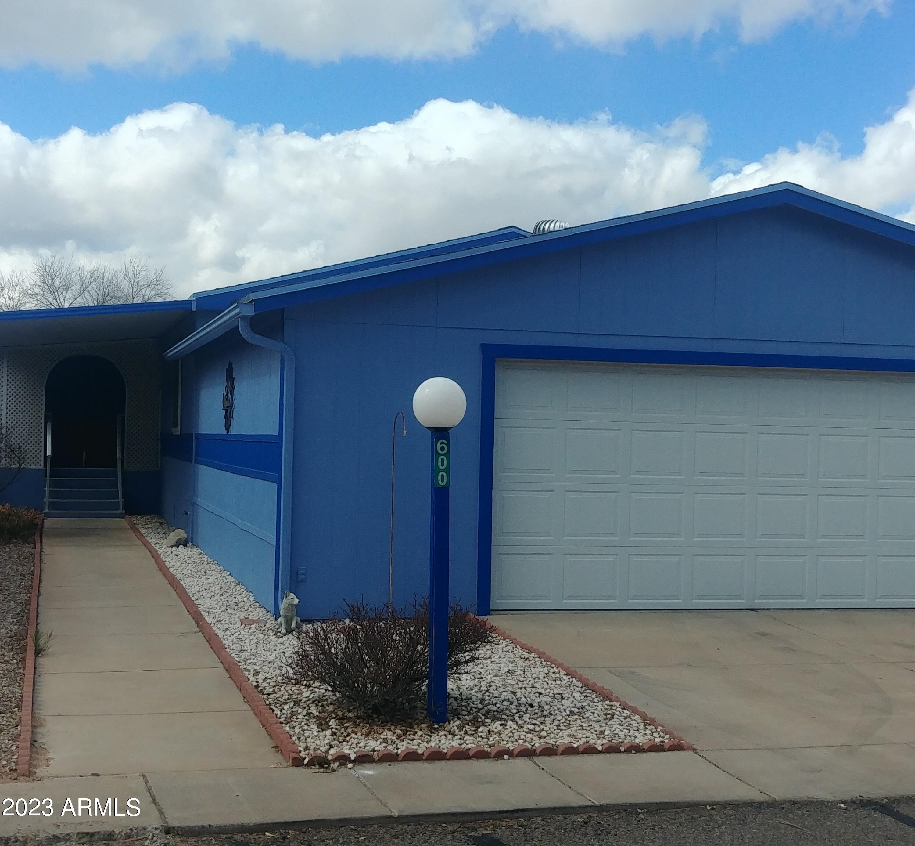 Very rare in the park! Full 2 plus car garage (approximately 26 ft. x 23 ft. ) with work benches. Water Heater, washer and dryer hook ups in garage. Also 3 additional parking spaces (one covered). 3 bedroom, 2 bath. Newer dual pane windows. Master bedroom has an addition that could be used as a retreat, office or additional  large closet. Each bedroom has a walk in closet. This home offers storage galore!!! A private front porch, a screened in back porch and a good size shed complete the outside of home.