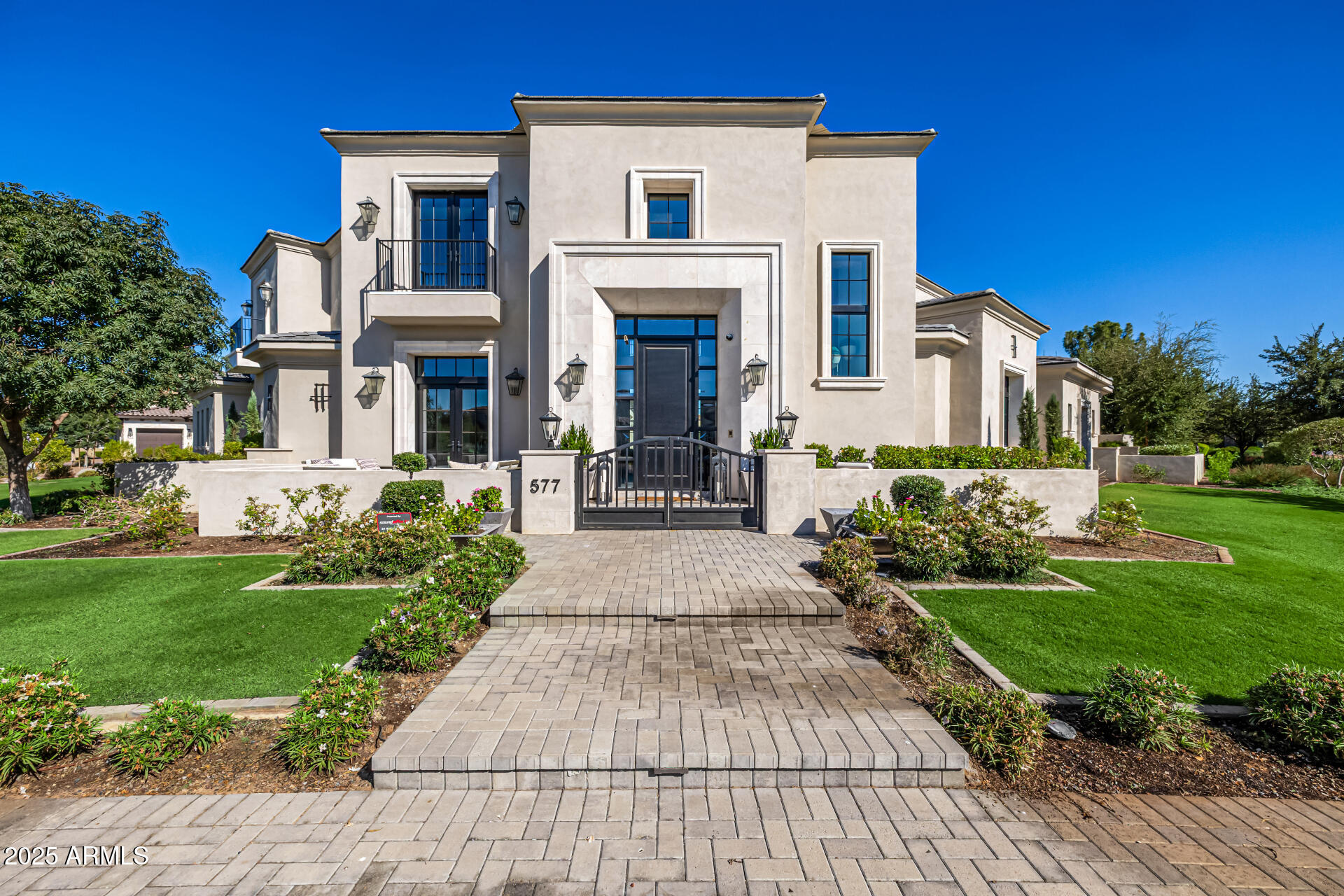 Experience extraordinary living in the exclusive, gated community on the Island at Fulton Ranch, located in the heart of Chandler. This 8,191 sq. ft. home offers 5 bedrooms, 5.5 bathrooms, and every amenity designed for comfort, style, and entertaining. Step inside to a dramatic two-story entry with a sweeping staircase, elegant crown molding, and a formal dining room complete with a climate-controlled wine room. The chef's kitchen is a showpiece with dual islands, Wolf appliances, Sub-Zero refrigerator, two dishwashers, custom cabinetry, and abundant natural light. A spacious family room with custom built-ins opens to the resort-style backyard. The main level features a luxurious primary suite, private office, exercise room, game room w/ golf simulator and a private guest suite.  Upstairs offers a versatile layout with 3 additional bedroomseach with en suite bathsand a bonus living space. The indoor/outdoor entertaining areas are one of the best features with retractable doors and endless possibilities for family gatherings. Enjoy the sparkling pool, spa, sport-court, built-in BBQ, commercial-grade misting system, turf for low-maintenance living, and plenty of room to gather. The property sits on a prime corner lot in a cul-de-sac offering exceptional privacy and space. Add a 4 car garage, owned solar, custom lighting and extensive moldings/built-ins throughout to make this a perfect fit for anyone.