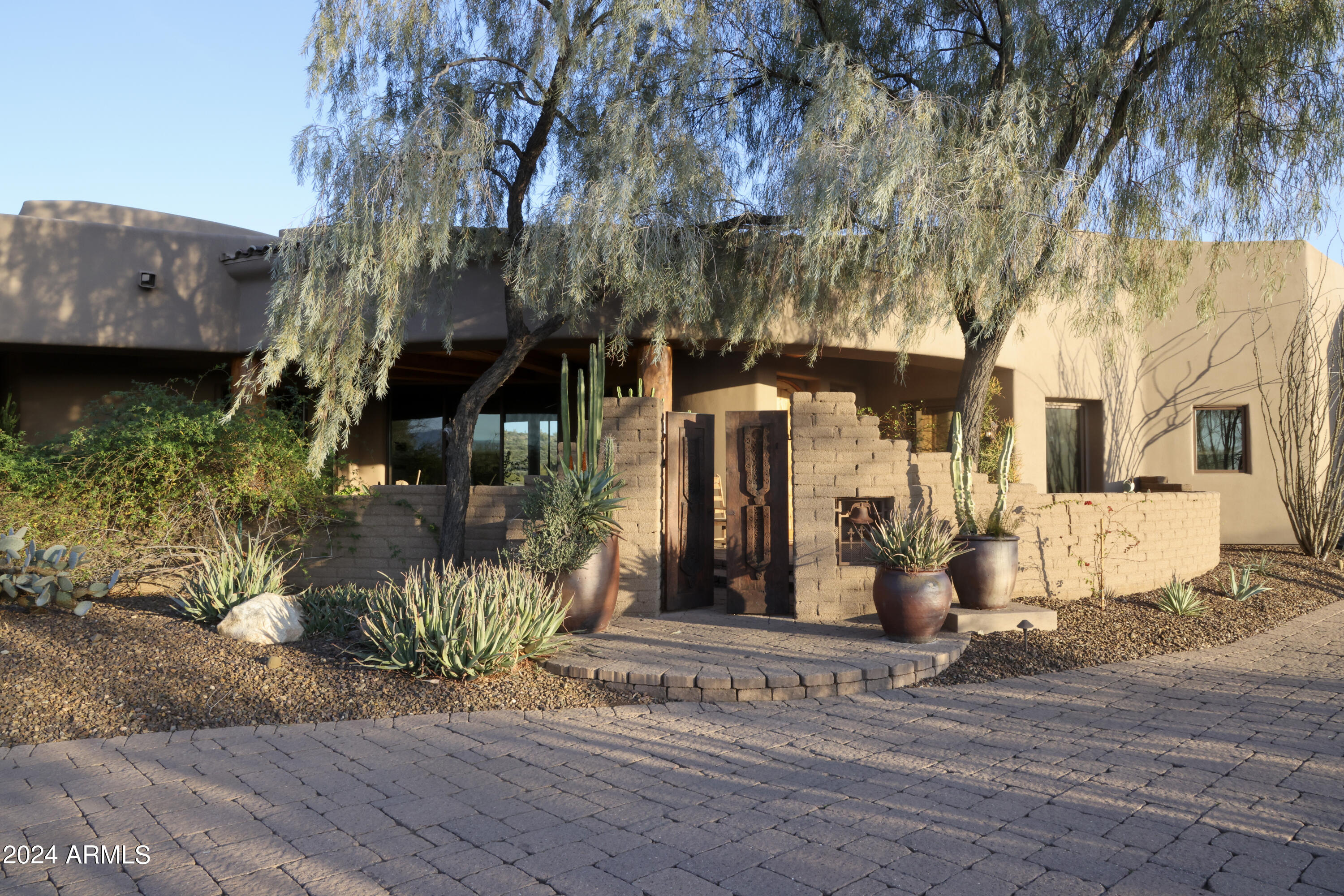 It's one thing to live in the desert. It's another to experience living in the Sonoran Desert. 
Welcome to Ocotillo Ridge Estates! This beautiful, John Schultz custom home is surrounded by mountain views, high desert vegetation and a variety of wildlife, that gives one the sense of communing with nature. 
The home is nestled on a 4.4 acre lot with numerous ocotillos, saguaros and other types of native plants and cacti. 
The driveway guides you past a  2 BR casita to the main house. Along the way, artisan crafted wood gates mark the entry points to the front patio and mesquite entry door. 
Once inside, you immediately notice that this is not your normal boxy home design. You'll also discover that every room is oversized. Distinctive elements, such as custom-built Alder cabinets throughout, provide the warmth needed to make this house a home. 
An open design allows hosts to entertain large gatherings without feeling cramped. There are 4 large sliding glass panels in the Great Room that hide into a pocket and allow the party to flow outside into an expansive covered patio. Turn up the sound system and enjoy!
The main house has 2 MBRs and 1 Ensuite BR. The MBR wing boasts an oversized MBA, a huge walk-in closet, a separate exercise room (with exit to an outdoor spa) and another door leading to a private outdoor shower. 
On the opposite side of the house, the other MBR has a sunken area perfect for reading, studying, working or just plain relaxing. A private exit to the large backyard and infinity pool can be found there as well. 
The main house also includes a chef's kitchen with a large island, walk-in pantry and breakfast nook. Stroll around to locate the laundry (with built-in ironing board), an office with 2 book closets, a Powder Room and a separate media closet to 'hide' all your audio/visual technology.
The casita, while under the same roof as the main house, has its own private entry and outdoor parking space. The design of interior is fashioned after a charming Mexican...casita, with a large family room, full kitchen and washer/dryer closet. The 2 bedrooms share a bathroom with a large walk-in tiled shower. Guests can access the pool, spa and back patio through a delightful side yard.
All you'll need to begin enjoying your new home in Carefree is there. After all, the town is not named Carefree for nothing...and neither is Ocotillo Ridge Estates!