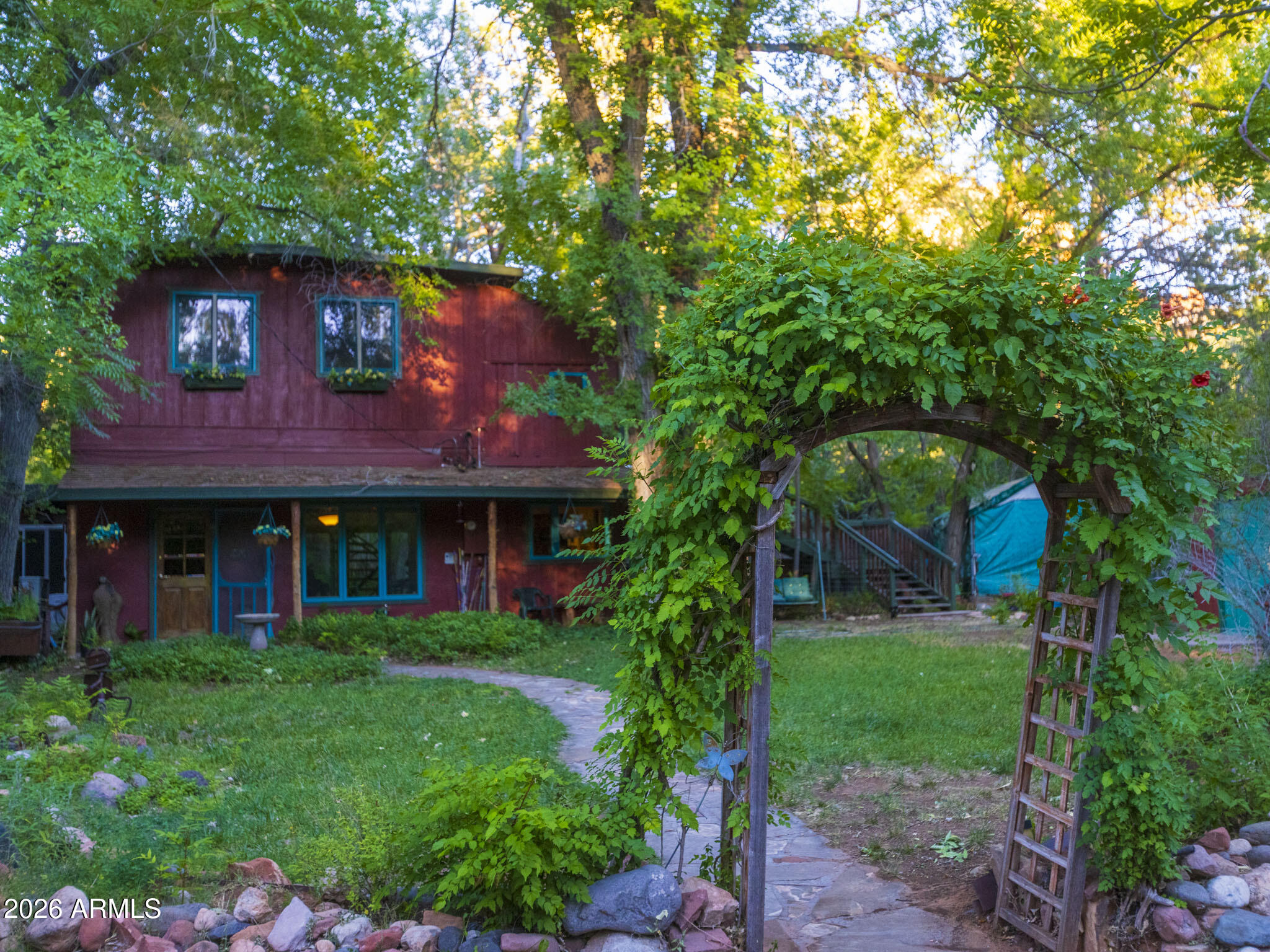Nestled at the end of a long cul-de-sac in the peaceful & intimate Bear Wallow neighborhood, this incredibly charming property offers a rare opportunity to enjoy the privacy of a quiet residential setting while remaining just minutes from Uptown Sedona and the beauty of Oak Creek.
Thoughtfully designed with versatility in mind, the home lives almost like a duplex. The upper level features a private one-bedroom, one-bath apartment with its own separate entrance & is currently operating as a successful Airbnb. Whether you're looking to generate supplemental income, create a long-term rental, or provide comfortable accommodations for extended family, guests, or a teenager seeking their own space, the possibilities are endless.  Both units can be rented together or separate as short-term rentals. Beautiful interior spiral stairs also connect both levels, allowing the home to function as one residence whenever desired. Situated on a spacious 0.30-acre lot, the main level offers two bedrooms plus a dedicated office, with the second bedroom featuring its own private exterior entrance. The cozy kitchen and intimate living area create a warm, welcoming atmosphere centered around a beautiful wood-burning fireplace. Filled with character and artistic charm, this is a home that invites you to slow down, relax, and truly feel at home.

If you've been searching for a property that offers privacy, flexibility, income potential and an unbeatable Sedona location, this Bear Wallow retreat is one you won't want to miss.