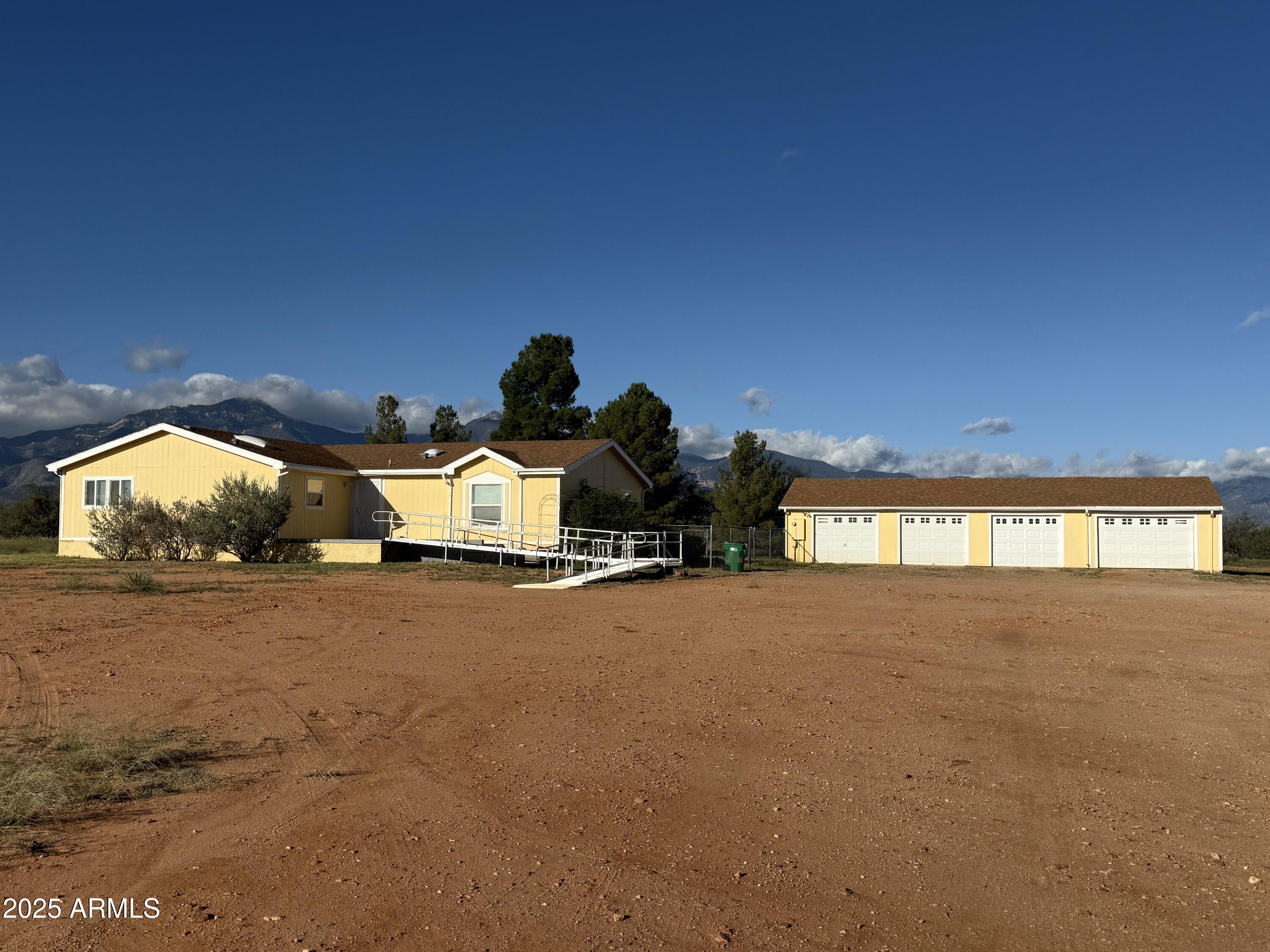 This is not a property that you will want to miss! This wonderful home has a large living/dining room that looks out to the backyard and Huachuca mountains through a beautiful wall of windows, a view you will never tire of! The kitchen boasts an island with breakfast bar and add even more storage! There is an enormous amount of counter space and room for ALL of your kitchen gadgets, There is a bright and sunny breakfast nook that looks out to San Jose Peak to the south. The master suite is good sized and has an amazing walk in closet with natural light. Th master bath features a beautiful garden tub and separate shower and new flooring. It was recently updated. The secondary bedrooms are split allowing for privacy and quiet. The main bath is fully handicap accessible. Step outside and you will find the fenced back yard with lovely pine trees. 
Next you will find the 4 car detached garage. The bays are deep enough for most pick ups. There is also a workshop area in the back with separate areas for different hobbies or storage. All this with a VA foundation and a 1/3 well share, and on a county maintained road. Don't wait on this one!