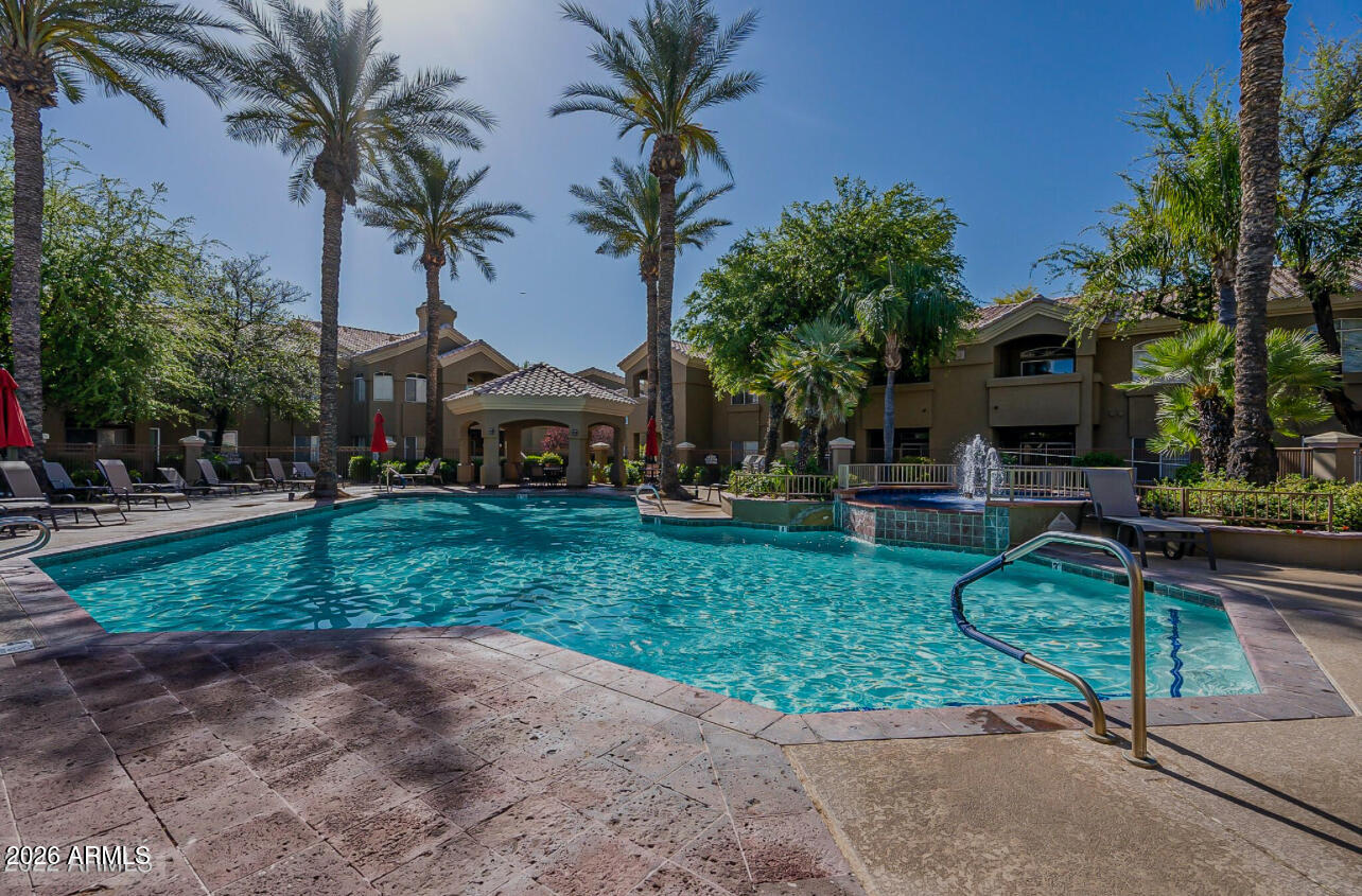 PARADISE VALLEY LOCATION, LOCATION, LOCATION!!!! This lovely unit with vaulted ceilings and an open floor plan is arguably at the Best Location within the entire complex with the back patio view looking at the pool. NEW CARPET in the Bedrooms and a NEW STOVE and a NEW AC recently installed makes this a perfect Turnkey opportunity for a permanent resident, rental situation or even a vacation rental. Imagine, a PARADISE VALLEY ADDRESS at this price!!!! This unit is within a secured gated community and it includes a coveted garage along with a conveniently located covered parking spot. Don't let this one pass you by!!!