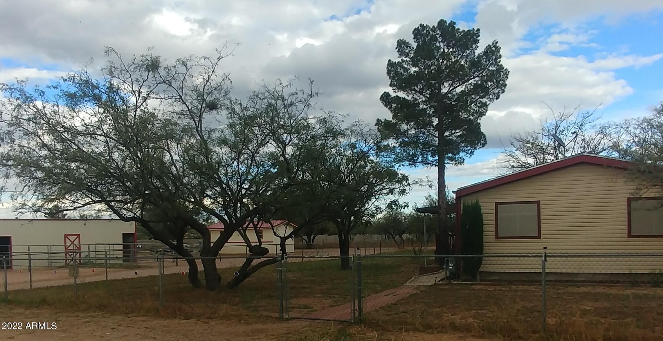 HORSE PROPERTY located just minutes to town with Horse Facilities. Split floorplan. 4 bedroom, 2 full baths. Living rom, family room, dining room, kitchen are open and roomy. Utility room is large enough for a chest freezer and has a butler panty feel with base and overhead cabinets next to the kitchen.  New upgraded carpet and laminate through out. Jacuzzi tub in master bath. Handicap accessible walk in shower/tub in hall bath. The exterior of the home is vinyl covered. Two handicap accessible concrete ramps. Approximate 12x24 building with concrete floor and new metal roof. This building could be converted to a one car garage by enlarging the door. Entire acre has new field fence (2021) w/Electric wire on most of it. Also chain link dog yard around home. 3 Stall Metal Barn Barn built in 2020. Barn is approximately 13x36. Has been used as a two stall with feed room. Enclosed shed row style. The barn has a variety of other potential uses. Small livestock enclosure, kennel or just great storage.