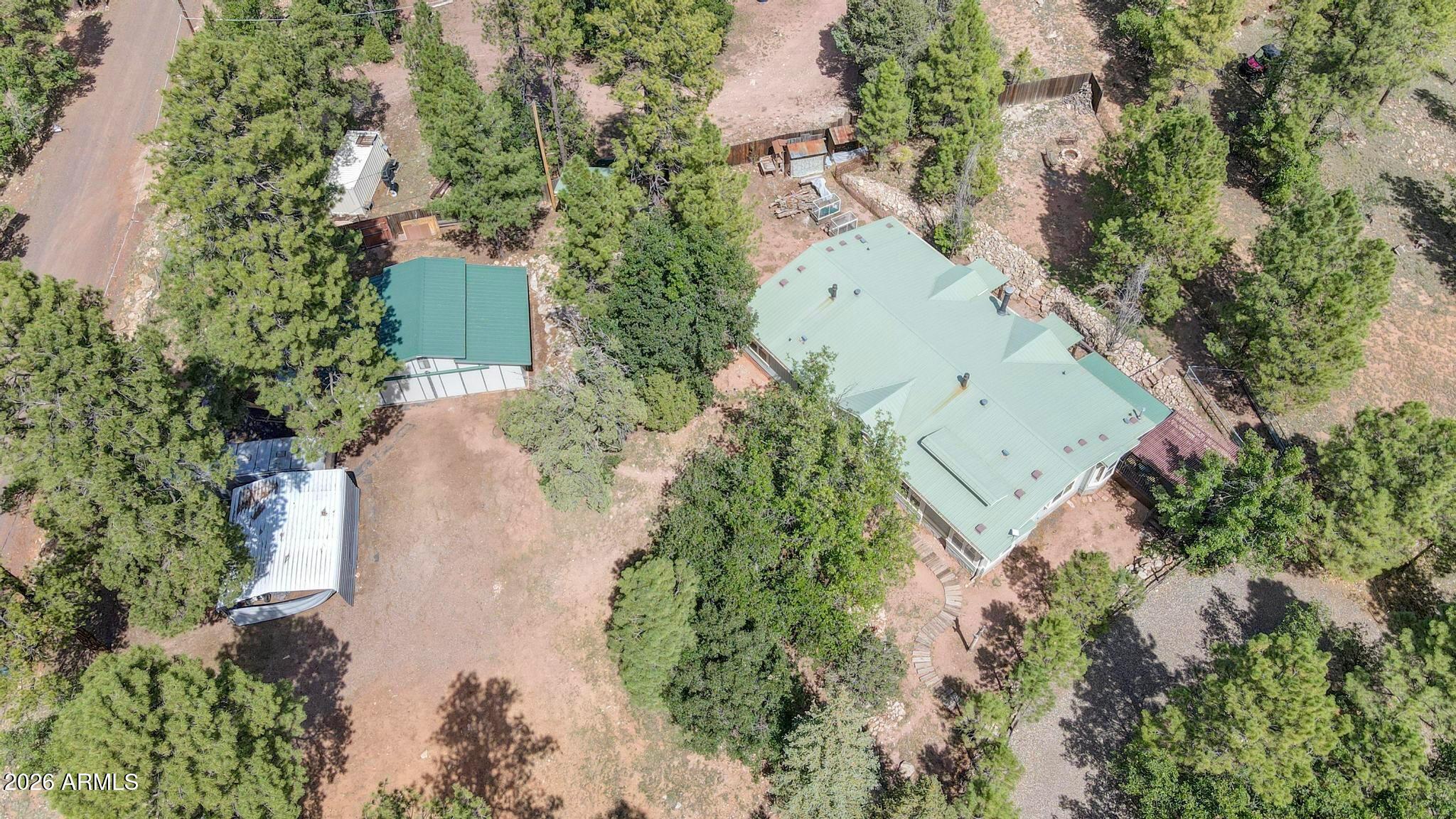 Endless possibilities to enjoy on this super spacious acre property, beginning with the home, located on a dead-end road 500 ft from the National Forest with many trails. Kitchen boasts a large walk-in Pantry, Breakfast Bar plus a center Island.  The new owners won't have a lack of space for ideas utilizing the many rooms in this triple-wide home. Presently there are 4 bedrooms, 2 ½ bathrooms, 2 dining areas & 2 great rooms.  These large rooms allow for a multitude of uses and enjoyment. The main bedroom, with French doors that open to an inviting deck, has an adjacent bathroom with jetted spa tub.  So many choices for comfort and pleasure. Owners try to keep the yard groomed for all 4 seasons and added a gathering fire pit area. The large Workshop used to be a mare motel - could be changed into any use the new owner will choose. Metal roof was new in 2015. Roads are maintained by  Coconino County in winter weather, and the circular driveway with RV gate helps make parking easily accessible. The RV pad has hookups , the yard has a dog run, and the Well house is in excellent condition since owner made it worry-free.  Sellers are offering $15,000 to new owners toward reflooring  all or part of this home. Come up and enjoy the fresh mountain air!