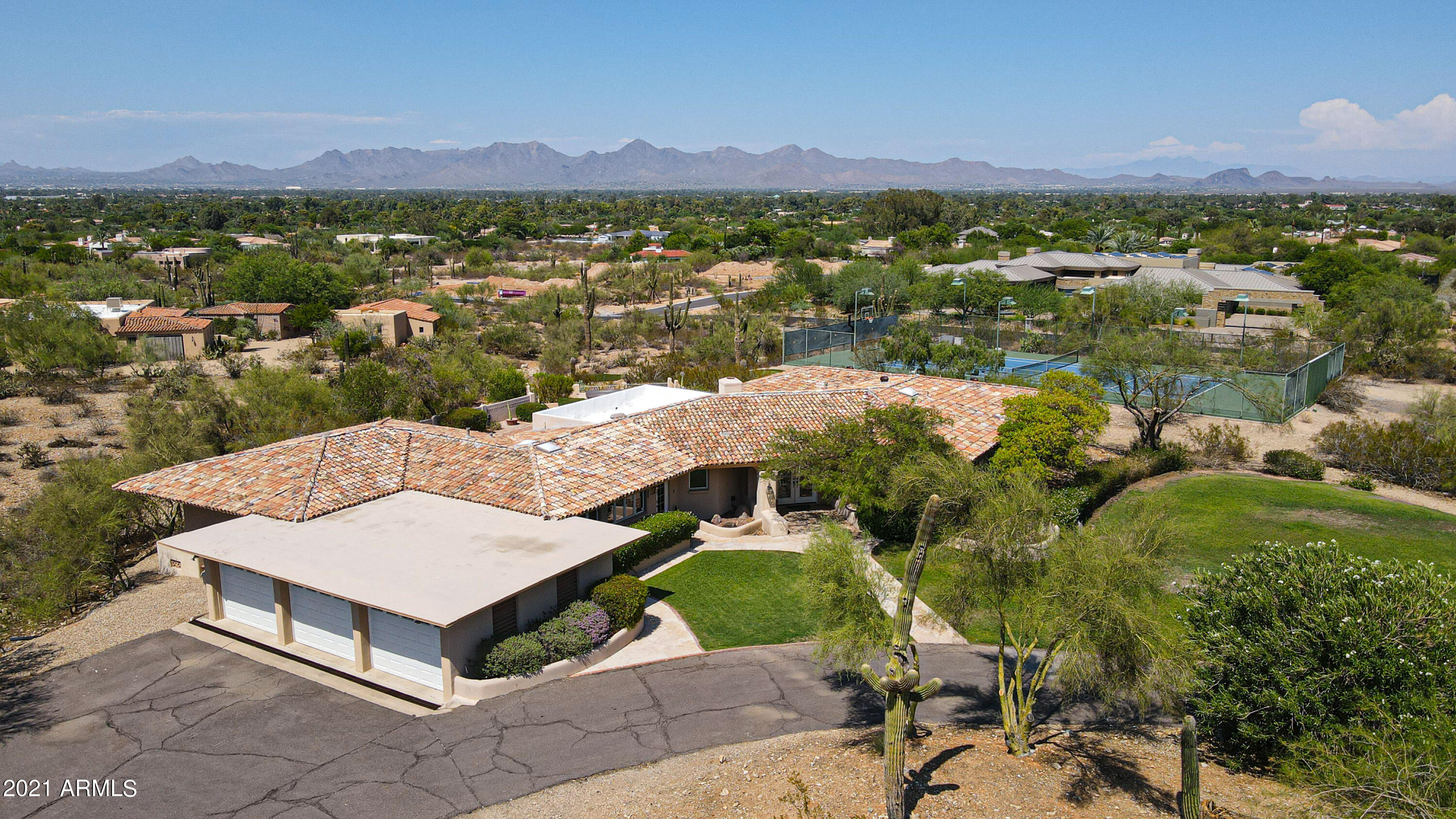 Spectacular Views, Views and more Views!   Prime elevated 1.85 acre, flat lot with a gentle slope.  NON HILLSIDE ORDINANCE.  Unobstructed views of Carefree, Pinnacle Peak and the McDowell & Mummy Mountains. Fabulous backyard for entertaining with a huge sparkling pool, bubbling spa, soothing sauna, BBQ and oversized tiled patio. Lower level has a putting green, driving range (net is in the garage) and grandfathered lighted tennis court with automatic ball server. Roam the interior of this multi-generational home to discover five large bedrooms, 2.75 baths and a master BR with a large sitting area. You'll enjoy the oversized family room with distressed wood flooring, movie theater size TV screen and attached guest bedrooms. Sellers prefer to sell the home furnished, call for details.