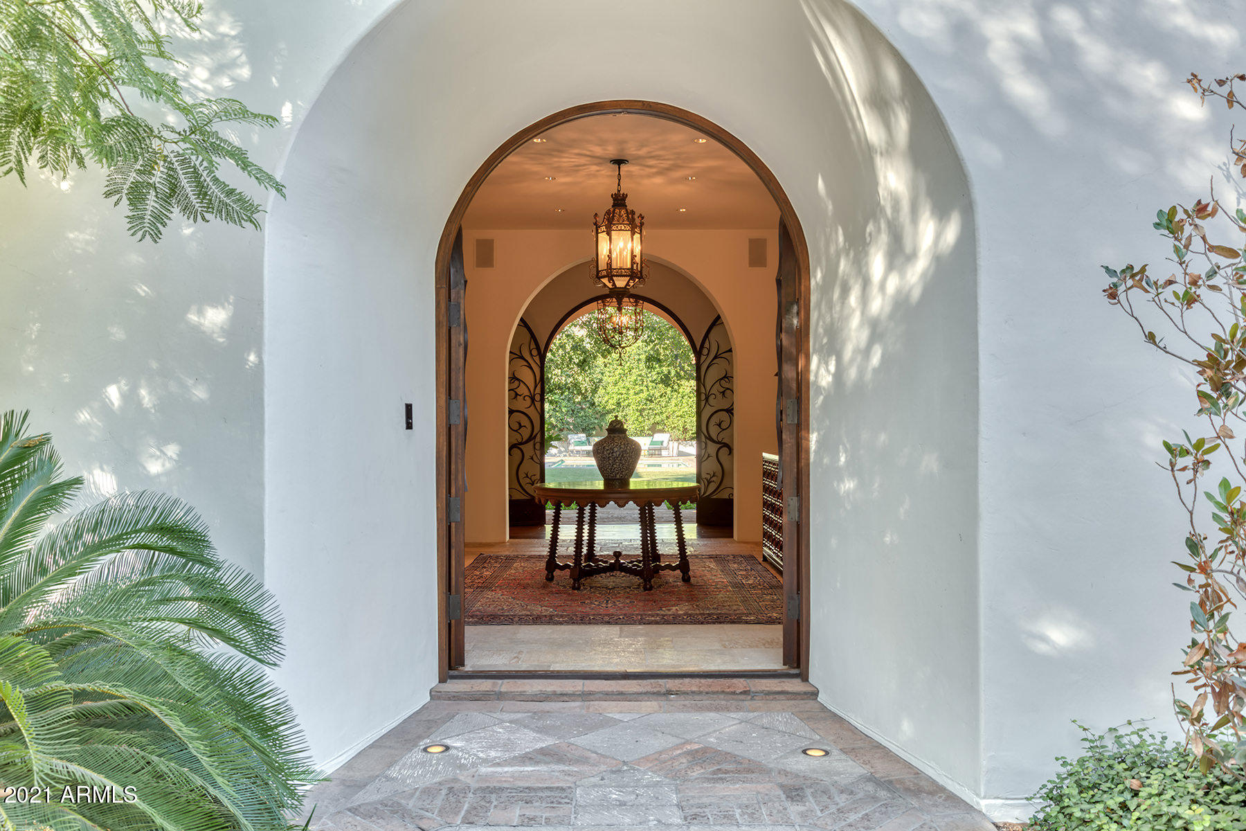 On a rare 2.25-acre lot, beautiful courtyards, hand-forged ironwork, tiled fountains, and smooth white stucco welcome you as you enter this timeless Santa Barbara estate.  A private well and a generator provide a sense of security most homes in PV cannot offer.  Desert  friendly landscapes and cool indigenous shade trees as well as a citrus garden; this beautiful estate was created from inception to provide indoor/outdoor living all year long.  In fact, every room opens to a shaded patio or courtyard, most with fountains or fireplaces.  Designed by renowned architect Clay Scrivner and built by Dan Madison, timeless quality and integrity of construction abound.  Wide plank hardwood floors and French limestone flooring are cool under foot.  Plastered walls, wood beams, coved ceilings... and niches are some of the interior elements to admire.  Walls for artwork with gallery quality lighting as well as beautiful sconces and chandeliers were tastefully selected for each room.  The sunny kitchen is the heart of the home with hand-painted tilework, honed marble countertops, and furniture quality cabinetry.  An adjacent butler's pantry includes storage for collections of china and glassware.  The kitchen opens to a true "Great Room" with a central fireplace and sliding walls of glass that pocket into the walls bringing the outdoors in.   True to its Hacienda style, the home opens from every room to  an expansive covered  and misted patio walkway.  The large grassy backyard with European style pool as well as a putting green enjoys a remarkable view of Camelback Mountain.  Guests will love the casita with separate access.  Its more lovely than any 5-star resort.  Temperature controlled 4-car oversized garage.