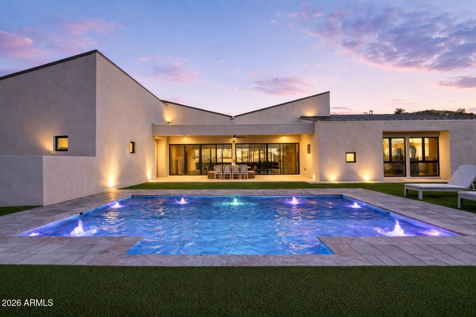 Luxury modern living in Estrella! This custom home on a gated cul-de-sac lot features 3 beds + office/den, 3 baths, and an oversized 3-car garage (853 sq ft) with 10ft RV gate/parking. Stunning design with vaulted ceilings, open kitchen/dining/living, and four 16ft multi-sliders blending indoor/outdoor living. Chef's kitchen offers quartz counters, waterfall island, walk-in pantry, skylights, and 48'' Bertazzoni range. Owner's suite boasts spa bath with freestanding tub, rainfall shower & huge walk-in closet. Oasis-style backyard includes a custom pool w/water features, spa, pergola, fire pit, BBQ & turf. Steps to Estrella's lakes, trails, pools, gym, dining & more—an AZ lifestyle at its finest!