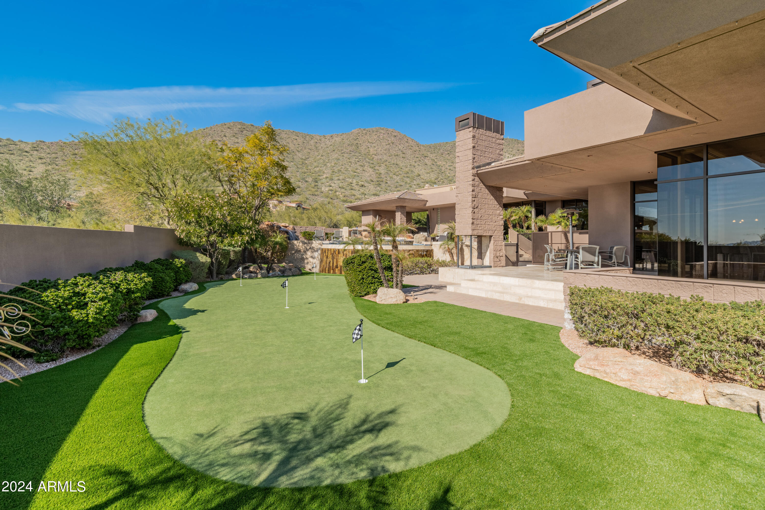 Exquisite & timeless in Ancala Country Club! This southwest contemporary estate nestled in the McDowell Mountains sits on a premium lot that offers stunning mountain, sunset & city light views. This sprawling 6226 sq.ft. custom home was carefully designed with the highest quality in mind, and it's been meticulously maintained by the original owners. The property features a split and open floor plan that includes 5 bedrooms (all with ensuite baths), 3 powder rooms, home theater, workout room, office, bonus/game room, and a 4-car garage. Upon entering you're greeted with an impressive great room - a true entertainer's dream. The open concept space features floor to ceiling window, a multi-slide door designed for seamless indoor/outdoor living, a large wet bar with wine cellar, custom built-ins, and cozy gas fireplace. The chef's kitchen features top of the line appliances (Dacor/Bosch/Asko/Subzero), expansive island w breakfast bar, and walk-in pantry. The primary suite boasts stunning floor to ceiling windows offering dramatic Camelback Mountain and city light views, a gas fireplace surrounded by custom cabinetry including a Subzero refrigerator drawer. The primary bath includes dual vanities, his & her toilets, towel warming drawer, jetted soaking tub, steam shower with multiple body jets and shower heads and a spacious primary closet with w/d. Adjacent to the primary suite is the workout room, home office with custom built-ins and guest bedroom with ensuite bath & walk-in closet. The guest wing includes a home theater with projector, 110" screen, 7.2 surround sound & 8 motorized reclining chairs, bonus/game room and 3 bedrooms, all with ensuite bathrooms & walk-in closets. 

The Resort style backyard boasts jaw-dropping views, a heated negative edge pool & spa with full glass tile finish, numerous water features including rock waterfall, dual fire pits framing the spa and a 3000 sq. ft. synthetic grass play area including a 5-hole putting green with chipping pad.  Multiple patios, covered and uncovered, offer various areas that include a built-in Dacor gas BBQ, wet bar w/ sink & fridge and pool powder bath. 

Recent upgrades and additional features include full interior & exterior repaint (2023), new carpet at bedrooms & living room (2023), Trane 18 Seer variable speed multi-zoned AC/heat pump system (all 4 units replaced in 2022/23), Fleetwood window system, Crestron Home Automation System that controls Audio, Video, Lighting, Security, etc. throughout the home, 8 ft solid core maple interior doors, owned solar system (70+ panels), motorized shade screens and window blinds, and a temperature controlled 4-car garage with porcelain tile floor offering plenty of cabinetry & storage.

Ancala is one of the most exclusive Private Country Club Communities in the Valley with a 24/7 manned guard gate. The Country Club (optional membership) is known for its picturesque views, par-72 championship Golf course and renovated Clubhouse featuring state-of-the-art workout facility, heated lap pool, tennis courts, restaurant and much more. This neighborhood is minutes from Mayo Clinic, hiking trails, BASIS Scottsdale & top Scottsdale schools (Anasazi EM, Mountainside MS & Desert Mountain HS). A truly unique & exceptional property that won't disappoint.