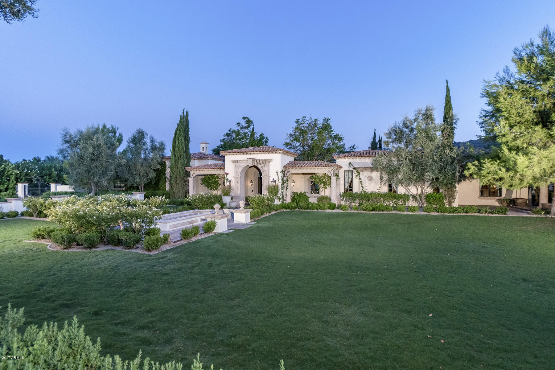 MRA handcrafted Mediterranean beauty on 1.39 acre lot in the heart of Paradise Valley. This home was designed with gracious living in mind. Fantastic floor plan including master retreat with his/hers baths, his/hers closets, wet room and private outdoor spa. Gorgeous fully wood paneled library/office, wine room, ultimate kitchen with the finest appliances and finishes. The media/game room opens to a huge covered patio, lush landscaping and green lawns plus a European styled pool with private ramada. Fabulous guesthouse featuring its own living room, kitchen, bathroom, and lots of closet space. Multiple fireplaces, lovely outdoor dining patios, privately gated.