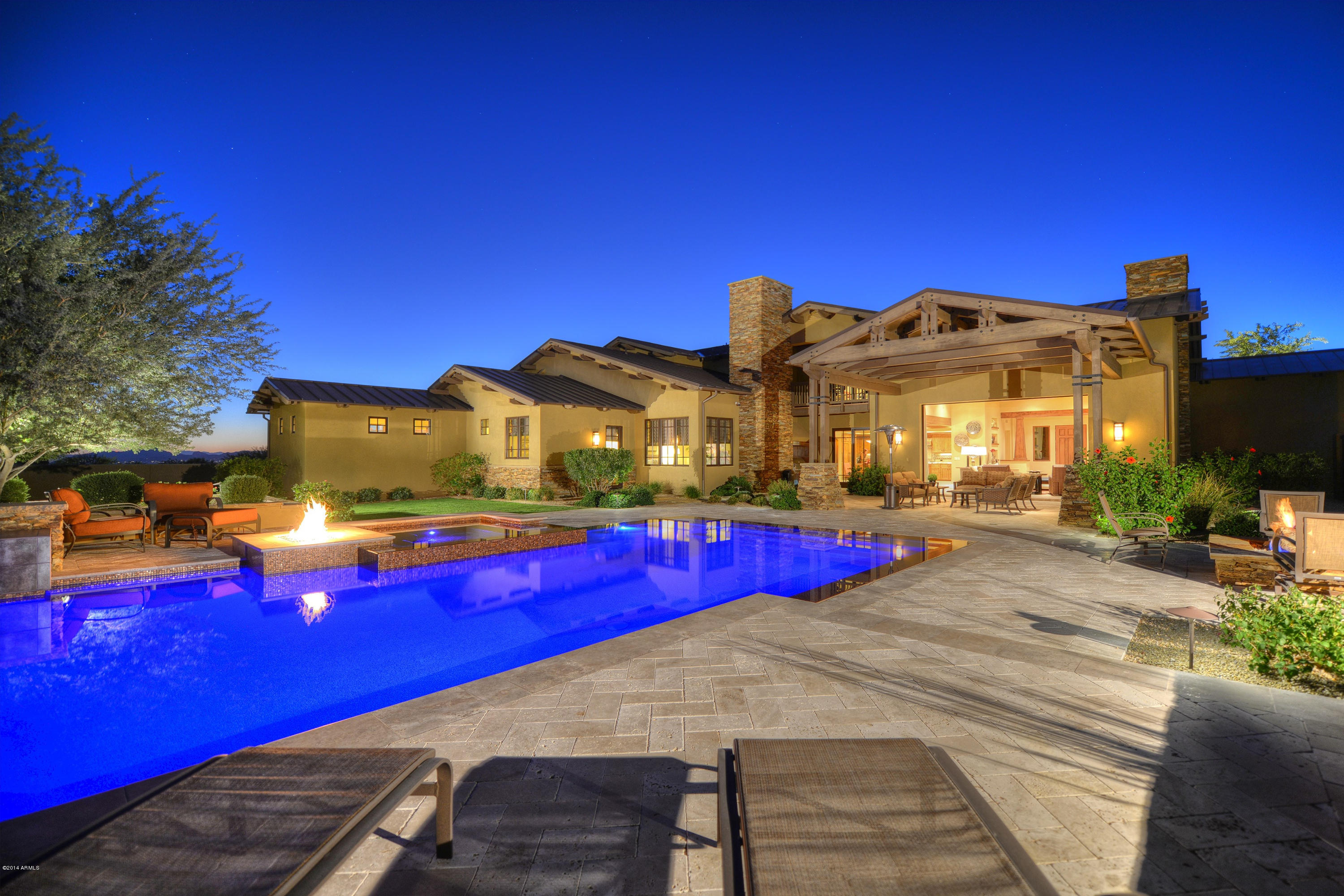 This extraordinary soft contemporary Craftsman style beauty is perfect for both family living & entertaining with front & back sliding pocket doors bringing the outside in! The curb appeal is evident starting with the green, green grass, stone & wood accents, metal roof, front porch w/travertine tile & a cozy firepit with glass rock. Enter through the oversized front door into this spacious yet intimate great room plan that flows through to the stunning resort style backyard w/heated salt water Pebble Sheen pool w/glass tile infinity edge & a spa adjacent to a sitting area & fire feature w/glass rock. An additional firepit/conversation area, built-in BBQ, mountain views and & being on a corner lot w/extended walls will make you feel like you are in your own private paradise! Inside you'l find a top of the line gourmet kitchen w/Wolf appliances, a sub zero refrigerator w/wine chiller, 6 burner gas cooktop, double ovens, Alder cabinets w/ rollouts and soft close features, slab granite counters, center island w/breakfast bar & walk-in pantry. 

The great room has a coffered & wood ceiling, stone fireplace & built-in entertainment center and all of the flat screen TV's convey. The dining room boasts a wall to wall buffet with granite top and pocket doors to the dining terrace. The 1st floor master has a fireplace & the luxurious master bath done in travertine has a Produits Neptune jetted tub, marble shower with dual heads, double raised height vanities w/makeup vanity & an enormous closet w/custom wood built-Ins. There are 4 more en suite bedrooms, all with travertine baths, makeup vanities & walk-in closets. 

You'll find the office/den downstairs, with wood floors and glass paned French doors to the front porch and the bonus/playroom upstairs, with a balcony that soaks up the gorgeous mountain views. Attention to detail is everywhere! There are 2 laundry rooms and 2 powder rooms (upstairs & down), Control4 home automation system, surround sound throughout, central vacuum system, a whole house water purifier, camera & security system. The paver stone driveway leads to a 4 car garage w/built in Cabinets, work bench w/utility sink and epoxy floor and there are 4 additional designated parking spaces. This magnificent home is one you'll want to see!