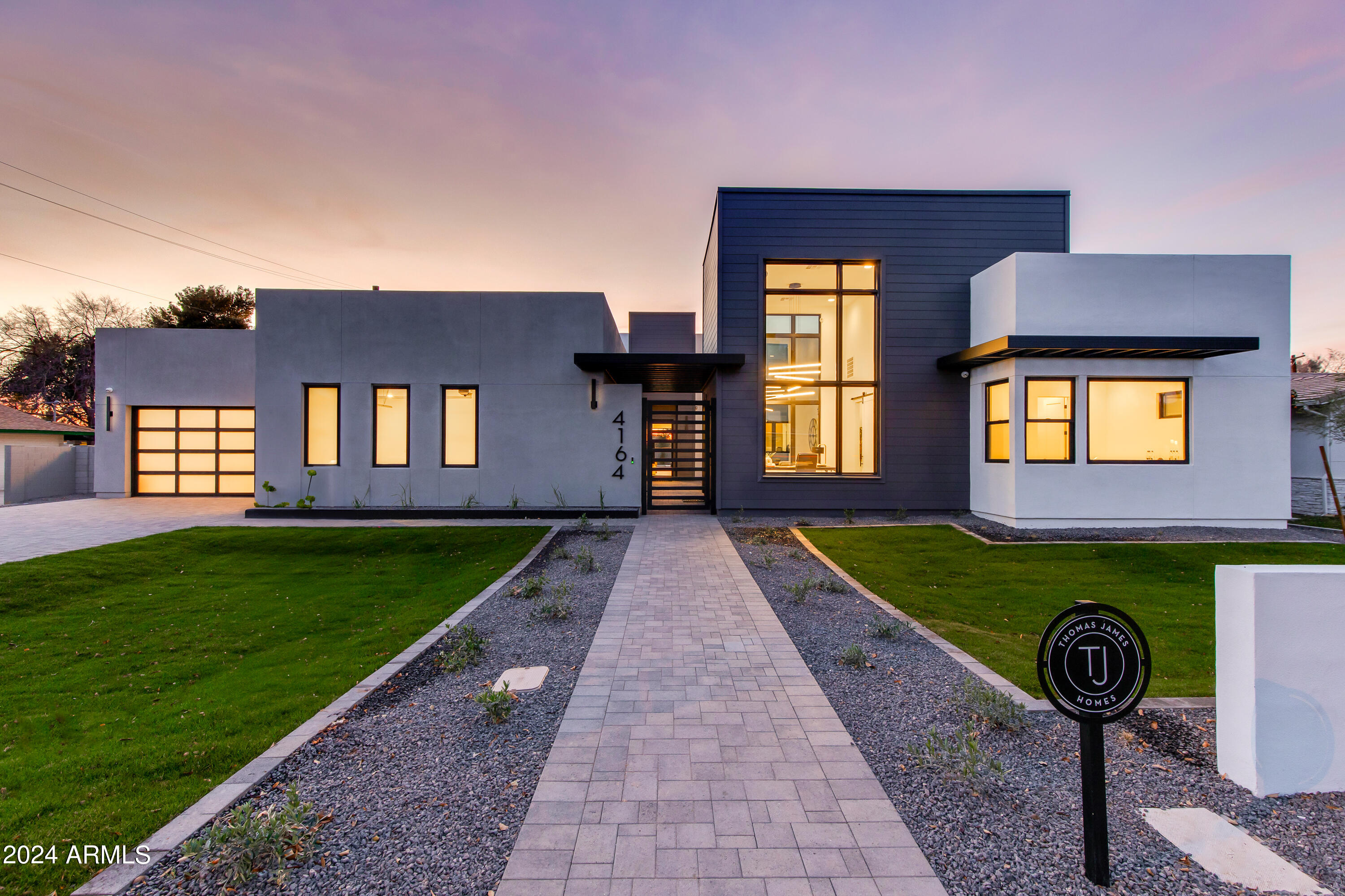 Introducing an exquisite modern home in Arcadia Lite by Thomas James Homes, designed by an award-winning architect. Situated on a quiet street, this 5-bed, 5.5-bath dream residence sprawls across a half-acre lot, offering 5,025 sqft of luxury and sophistication.
Every detail has been meticulously considered, from wide plank wood flooring to impressive custom lighting, outstanding millwork and decorative ceilings and wall treatments. The open-concept floorplan is designed for contemporary living, and the perfect blend of indoor/outdoor harmony. A welcoming interior courtyard leads to the elegant entrance. Inside, an entertainer's delight awaits, featuring a magnificent floor-to-ceiling fireplace in the great room, adjacent to a gourmet kitchen equipped with top-of-the-line appliances, a prep kitchen, a generous dining room, and additional seating at the expansive quartz countertop island peninsula, providing space for up to six guests. The grand suite is a retreat in itself, featuring a spacious walk-in closet and a spa-like bathroom with a freestanding tub and an expansive walk-in shower. Each of the secondary bedrooms includes its own en-suite bathroom and ample closet space. To top it off, there's added living space with a private office and an adjoining bonus room. Natural light floods through expansive windows and multi-slide glass doors. The exceptional finishes extend outdoors, to the fully landscaped front and back yards, including a pool and spa, outdoor kitchen and firepit to enjoy Arizona outdoor living. Located in the coveted circle of Arcadia Lite, this home is minutes away from all that Arcadia has to offer.