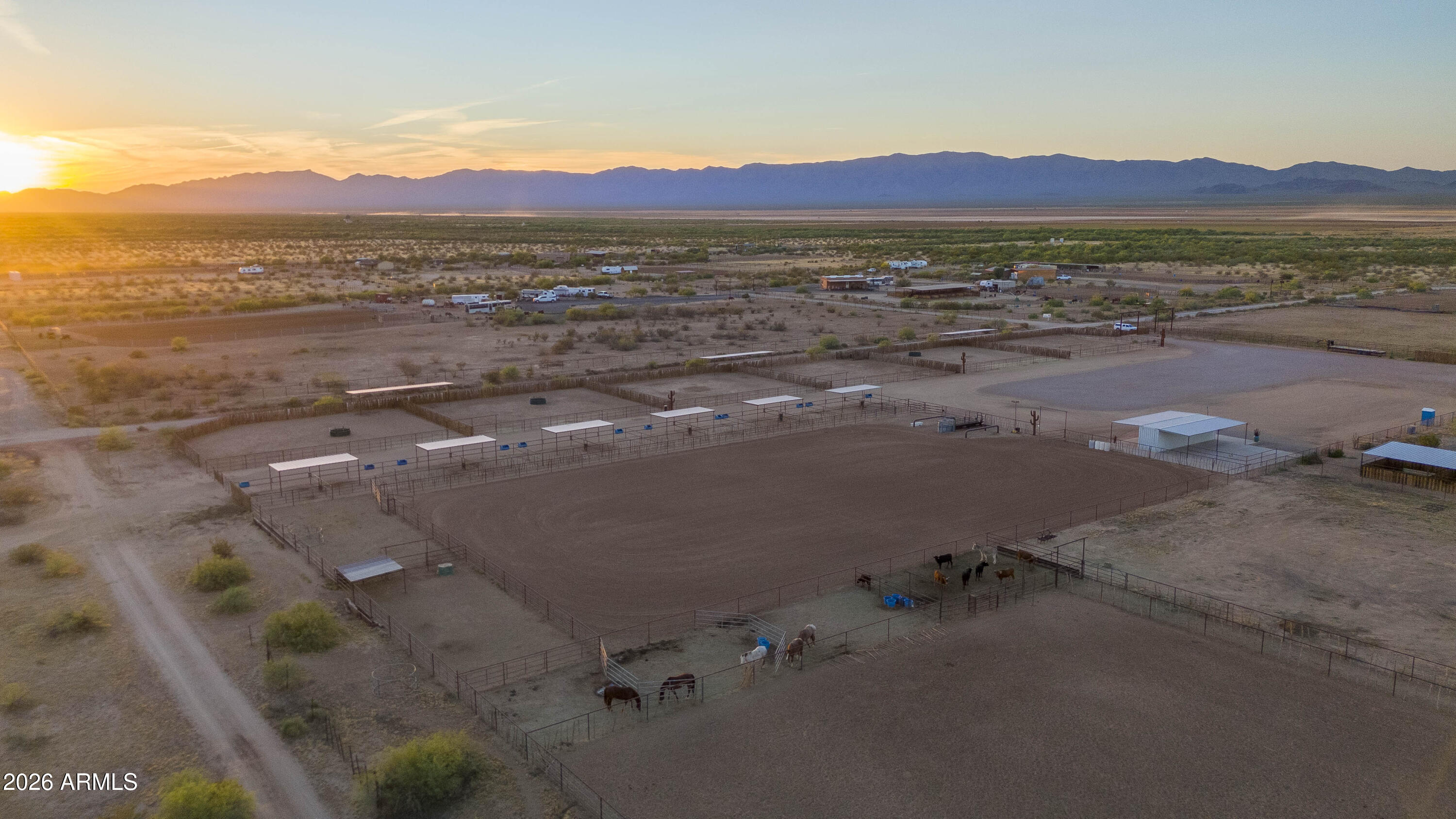 This 5 acre, turn key property is set up and ready to go. Designed with the serious horseman in mind, this property features six 100'x100' turnouts plus twelve 24'x24' pens with shade and automatic water. The roping arena has everything you need to step right into training, roping or running a business. There are covered pens and waters for the steers at the back end of the arena, the automatic chute stays and the ground is flat and meticulously maintained. The connex boxes with shade provide a versatile space for storage, tack or farrier workspace complimented by a concrete patio and large wash rack area. Two full RV hook ups make it easy to accomodate guests, clients or seasonal help.  Whether you're looking to operate, invest or enjoy the Arizona lifestyle, this property is dialed in and ready. Seller may carry on this one!