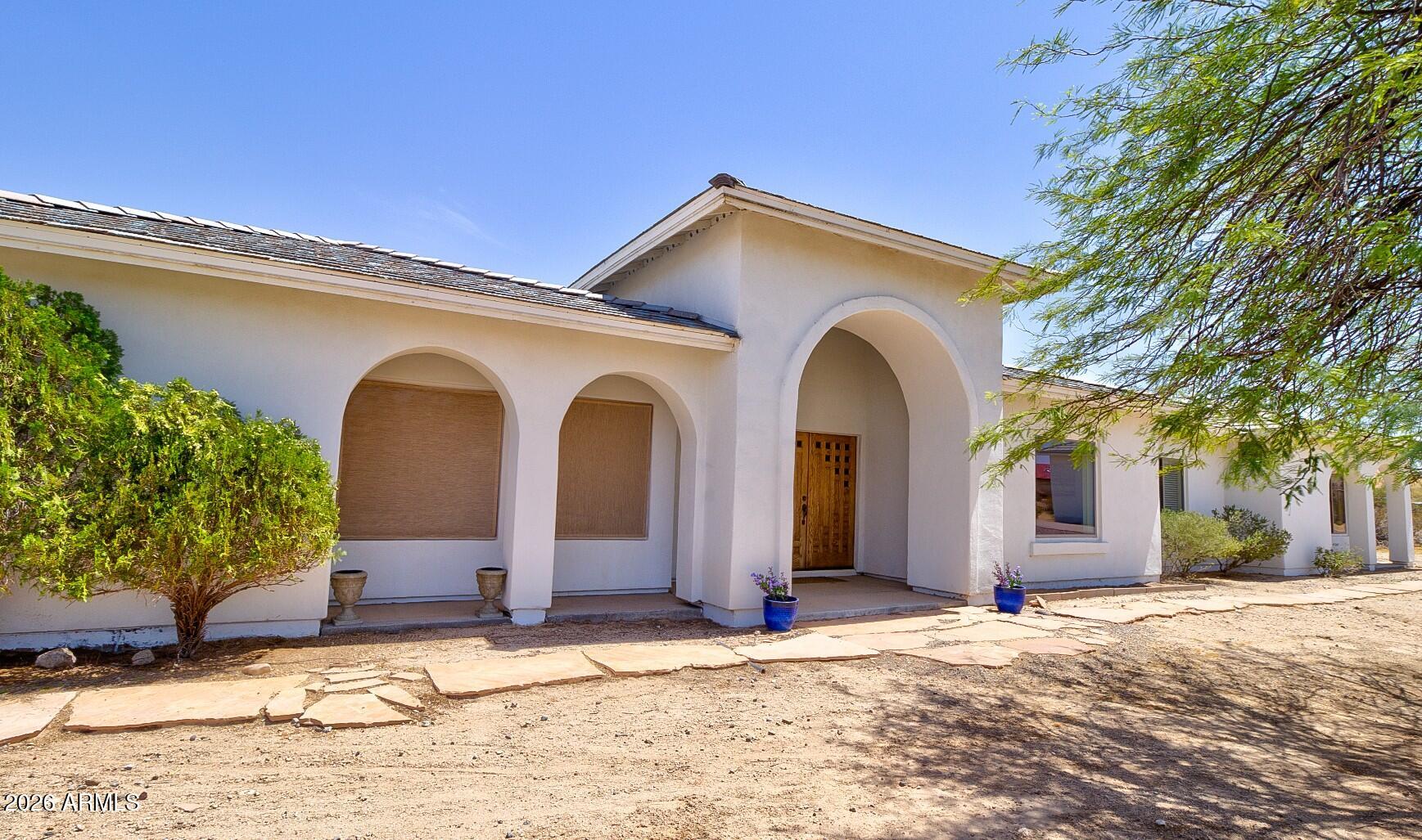 Beautiful custom home on 2.1 fully fenced acres with mountain and city views and no HOA! Designed for entertaining, open floor plan features a formal living room, dining room, family room, and a stunning atrium with skylights. The eat-in kitchen offers double ovens, a butcher block island with storage, 42'' cabinets, and a deep pantry. Tile flooring throughout, ceiling fans in all bedrooms,  laundry room cabinetry. Enjoy the enclosed pool area and irrigated desert landscaping. Energy-efficient upgrades include owned solar, a new AC/heat pump, new heat pump water heater, and new pool pump. Attached garage includes a 240V EV charger outlet. A separate 32 by 32 studio or 2-car garage finished and insulated. Improved roads and great neighbors!