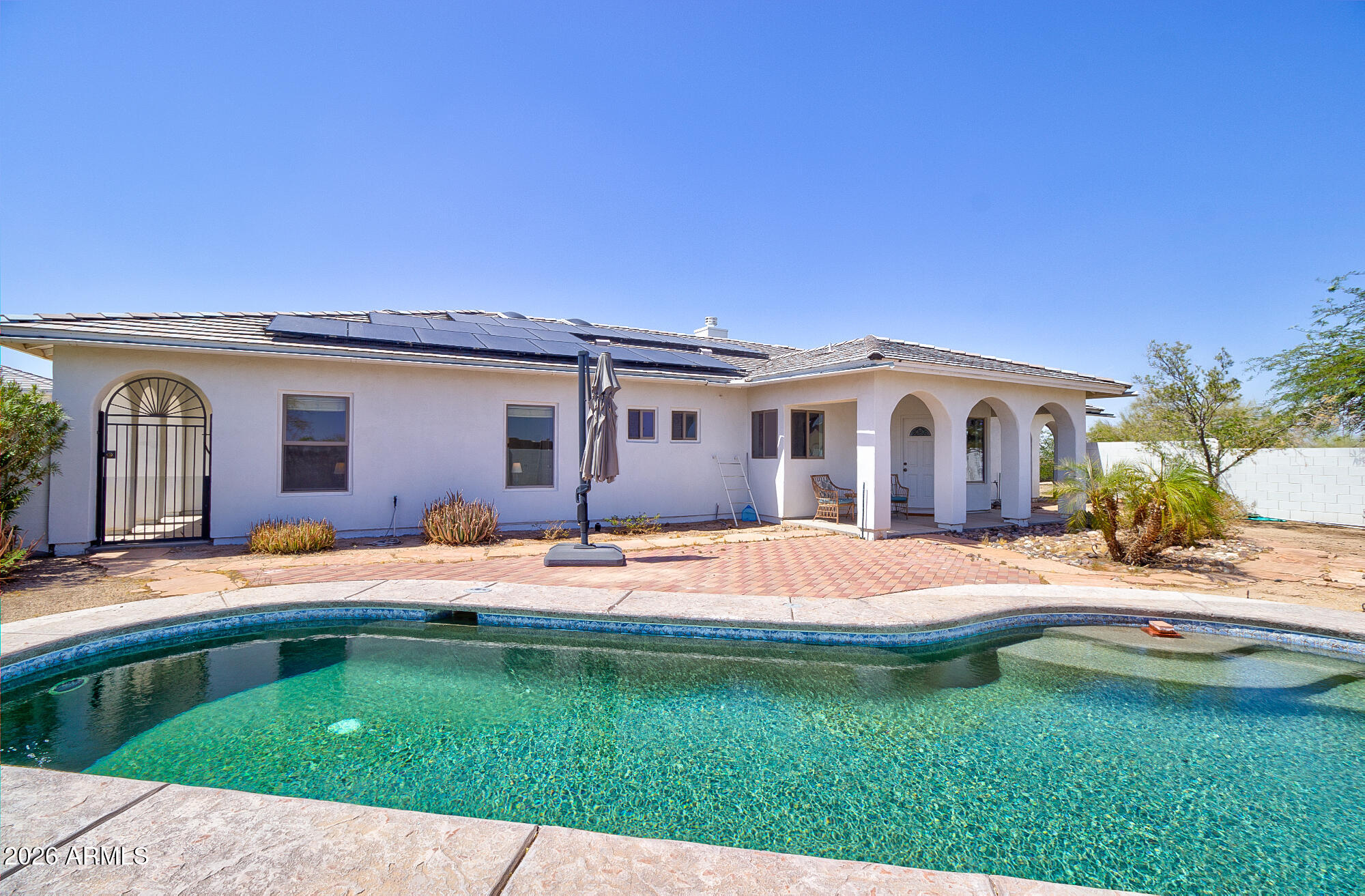 Beautiful custom home on 2.1 fully fenced acres with mountain and city views and no HOA! Designed for entertaining, open floor plan features a formal living room, dining room, family room, and a stunning atrium with skylights. The eat-in kitchen offers double ovens, a butcher block island with storage, 42'' cabinets, and a deep pantry. Tile flooring throughout, ceiling fans in all bedrooms,  laundry room cabinetry. Enjoy the enclosed pool area and irrigated desert landscaping. Energy-efficient upgrades include owned solar, a new AC/heat pump, new heat pump water heater, and new pool pump. Attached garage includes a 240V EV charger outlet. A separate 32 by 32 studio or 2-car garage finished and insulated. Improved roads and great neighbors!