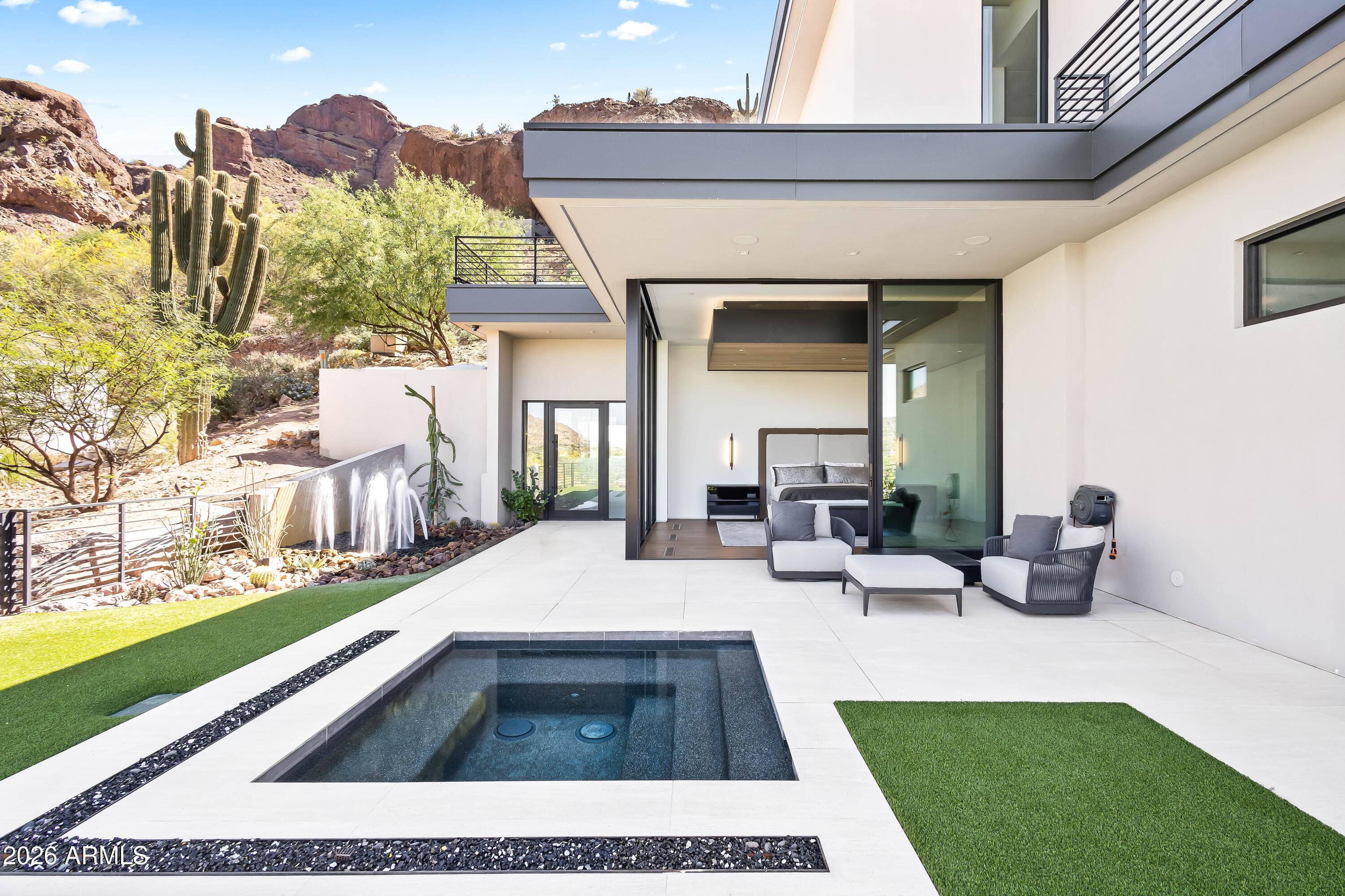 Perched on the iconic slopes of Camelback Mountain, this exceptional hillside estate by Brimley Development, designed by renowned architect C.P. Drewett, offers a rare blend of modern architecture and breathtaking natural surroundings in the heart of Paradise Valley. Capturing sweeping views of mountains, city lights, and golf courses, this striking two-story residence is defined by soaring ceilings, wood-paneled architectural details, and expansive walls of glass that seamlessly connect indoor and outdoor living. The great room is a true showpiece, featuring a dramatic stone accent wall, two-way gas fireplace, and retractable glass sliders that open to an infinity-edge pool wrapping the home--creating the ultimate Arizona indoor/outdoor lifestyle. The open-concept layout flows effortlessly into the formal dining area, wet bar, and chef's kitchen, ideal for entertaining. The gourmet kitchen is appointed with a rare Crystallo Quartzite island and backsplash, premium Sub-Zero and Wolf appliances, and a fully equipped butler's pantry with Miele coffee system. The luxurious primary suite offers a private retreat with its own patio and spa, along with dual vanities, separate water closets, a freestanding soaking tub, oversized steam shower, and a custom infrared sauna. Additional highlights include a private guest casita, elevator, home gym, bonus room, and a 3-car garage with ample additional parking. The resort-style backyard features an outdoor kitchen, completing this extraordinary desert estate. Just minutes from Arizona's top resorts, golf, dining, and shopping.