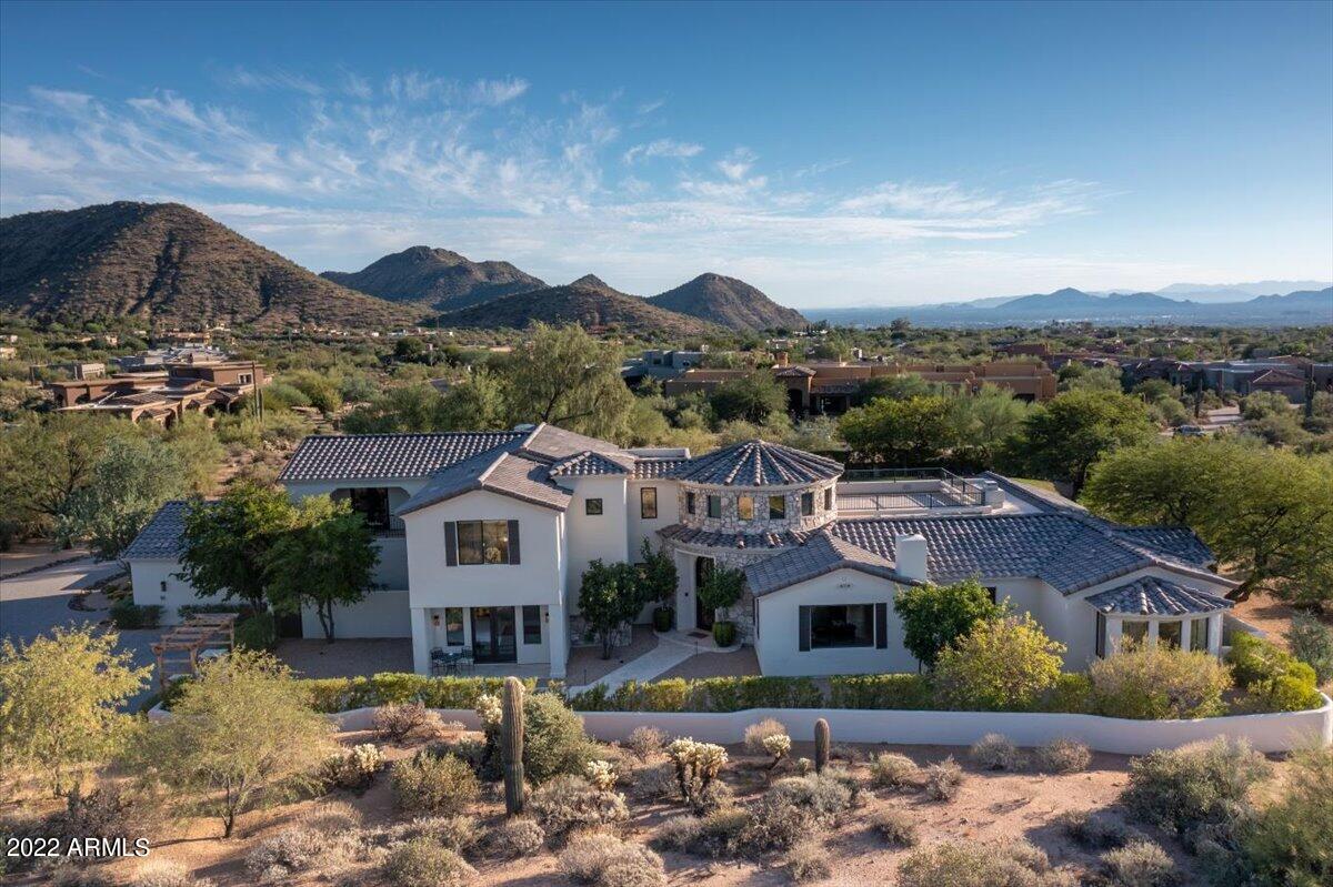 Secluded & Private! Get ready to be amazed by this North Scottsdale showstopper located in the gated community of Ladera Vista, with 360 degree dazzling views of Pinnacle Peak, Troon Mountain, and the McDowell's. This four bedroom, five bath home sits on an enormous 2.5 acre lot, offering you endless privacy and unbeatable sunset mountain views from the rooftop deck. Enjoy the incredible natural light of the south/southwest orientation, which keeps the home sunny and bright all day long.

The home underwent an extensive custom remodel in 2020, and you can see where the upgraded finishes and details shine in every corner of the property.

Whispering Wind feels grand from the moment you walk into the foyer, with a regal iron spiral staircase and statement light fixture... ...The captivating kitchen has gorgeous, airy white cabinets, a gas cooktop, double ovens, and a massive center island. The open concept kitchen spills into a cozy family room with floor-to-ceiling windows and exposed beam detailing on the ceiling. 

This home brings the best of the desert inside, with incredible entertaining opportunities in every room. The formal dining area has an attached butlers pantry with room for a full sized wine fridge with plenty of storage, and a multi-slide glass door system that fully opens unto the backyard.

Soak in the incredible backyard views while you lounge in bed from the primary suite. The primary bedroom has the same gorgeous exposed wood beams on the ceiling, with an updated modern fireplace.

The spa-like primary bath features beautiful tile detailing, has double vanities and a soaking tub where you can take in panoramic views of Pinnacle Peak to the North. 

The first floor includes a well-appointed office with a full wall of custom shelving, a cozy sitting room with fireplace, and a modern ensuite guest bedroom and powder room. Upstairs you'll find two more bedrooms and a loft/bonus room that could be used as a playroom or movie room.

This backyard oasis offers every amenity you could dream up, with a full outdoor living room, perfect for watching the game on a beautiful Fall day. Further out into the yard there is a spectacular pool with a Baja shelf, hot tub, and fire pit. 

The crowning gem of the property very well may be the rooftop observation deck, with sweeping views of the surrounding Sonoran Desert & Mountains, Spectacular Sunsets and City Light Views!!!

This home offers the ideal blend of tranquility while still being moments away from Scottsdale's best shopping and dining,  with the Scottsdale Quarter and Kierland a quick jaunt down the hill, and local grocery stores like AJ's Fine Foods just around the corner. You're also only minutes away from Pinnacle Peak and Tom's Thumb Trailhead, two of the premiere hiking and mountain biking trailheads in the city!