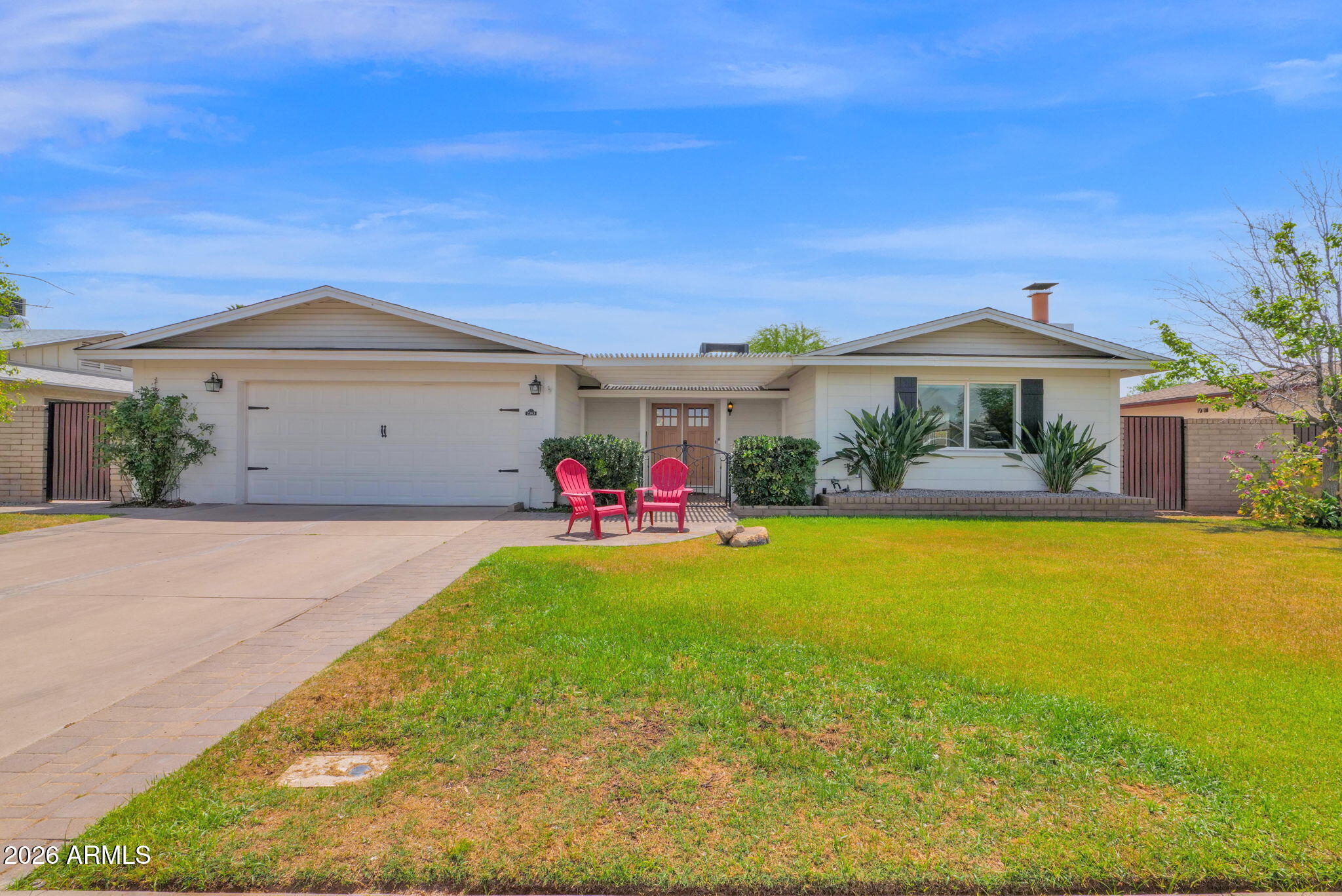 Welcome home to one of the most thoughtfully upgraded properties in the neighborhood -- where standout features, smart design, and sits on a coveted north/south lot that delivers shade on both patios year-round.
Arrive to a spacious front patio and make your entrance through elegant double doors into a proper foyer -- a rare find in this area. Inside, a split floor plan (another neighborhood standout) gives everyone their own corner of the house. The open living and dining area is anchored by a wood-burning fireplace and flows naturally to the kitchen and beyond.
The remodeled kitchen is a true chef's workspace: updated cabinetry with deep pull-out drawers, a farmhouse sink, quartz countertops, an induction cook-top with pot filler, and a built-in oven/microwave with convection setting, essentially a double oven on demand. The island adds counter and storage space, while pass-through windows to the back patio make entertaining seamless indoors and out.
The primary suite is a genuine retreat, complete with a built-in wardrobe in the en-suite bath. Double sinks in both bathrooms -- a detail you won't find in most comparable homes here. Wood-look tile, canned lighting, and quality finishes throughout tie it all together.
Step outside and enter your own private resort. The covered patio is built for gatherings -- equipped with misters, ceiling fans, a Ramada, and a BBQ grill. The remodeled PebbleTec pool features a Baja shelf and basketball hoop, making it the ultimate Arizona oasis. Additionally, two generous side yards add more space for a dog run or other projects.
The garden space is extraordinary. Raised garden beds on a timed irrigation system currently produce rosemary, multiple pepper varieties, mint, and pumpkins, while a mature orchard of lemon, mandarin, peach, pomegranate, and grape plants rounds out a true gardener's dream backyard.
Additional highlights: attached garage with extra storage space (many homes in this area have only a carport), and year-round natural shade from the north/south orientation.