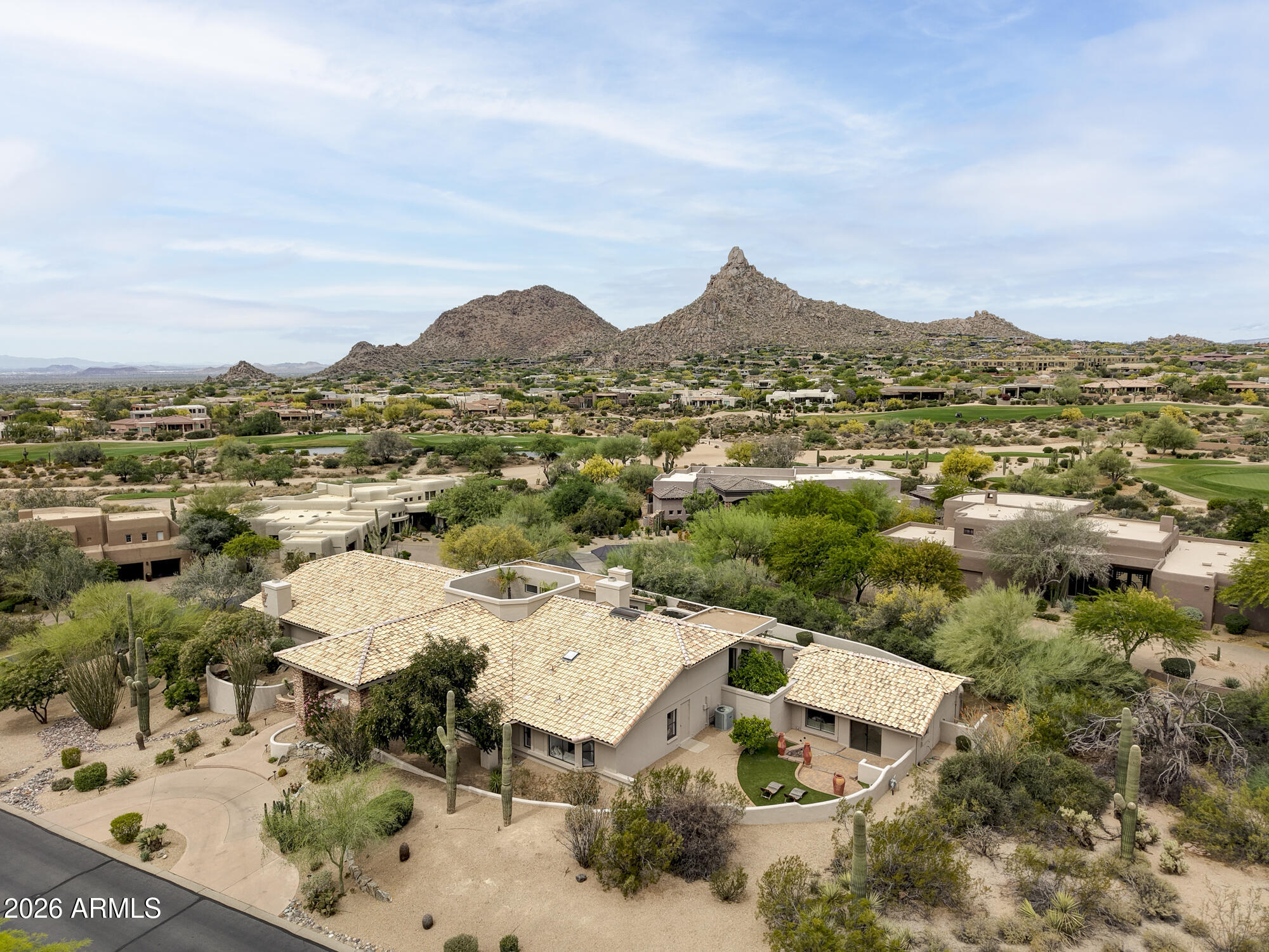 Stunning 6,090 sqft. modern desert contemporary estate with striking architectural design showcasing dramatic MOUNTAIN VIEWS, city lights, and iconic Pinnacle Peak, all within the prestigious guard-gated Windy Walk Estates--featuring a 24/7 manned guard gate and security patrol and recognized as one of the most beautiful communities in Maricopa County. This home is a true showstopper where privacy and scenery take center stage on an almost acre-sized lot.
Offering 5 bedrooms and 5.5 bathrooms the home also includes a dedicated office, spacious family room, versatile game/bonus room, and includes a separate 1 bed/1 bath guest casita--perfect for guests or multigenerational living. The floorplan is open concept with a spacious great room where the kitchen is open to lounging areas, and the ensuite bedrooms are nicely separated into wings.
Expansive windows and soaring ceilings fill the home with natural light, highlighting its distinctive architectural design and seamless connection to the surrounding landscape. Nearly every room captures breathtaking mountain views, and perched high within the community, the home truly lives up to its nickname "the bird's nest." The atrium at the center of the home creates seamless indoor/outdoor living. 
The primary suite is a private sanctuary, complete with a sitting room with 2-way fireplace, an oversized spa bathroom with dramatic custom built-in dry sauna, and a resort-style walk-in shower designed for ultimate relaxation. 
Step outside to an entertainer's paradise. Enjoy the impressive 45-foot pool, unwind in the secluded hot tub, or refine your short game on the putting green, all set against the dramatic backdrop of Pinnacle Peak. The grounds are nothing short of extraordinary--a lush desert oasis featuring a curated blend of saguaros, ironwoods, palo verdes, ocotillos, and mature citrus trees including orange, grapefruit, and lemon. 
The home has block construction which is an added benefit for insulation/temperature control. An extra-deep 3-car garage with storage closet provides ample space for luxury vehicles, storage, or hobby needs.
Perfectly positioned within the most exclusive area of Troon, this home enjoys a prime location with temperatures typically 6-8 degrees cooler than the Valley floor. WALK TO TROON COUNTRY CLUB, or take a short drive--under 5 minutes-- to the Four Seasons Resort for a weekend brunch at Proof or elegant dinner at Talavera. Everyday conveniences and upscale dining within an 8-minute drive includes:  AJ's Fine Foods, Starbucks, Mastro's Steakhouse, and Walgreens. Loop 101 freeway is just 13 minutes away. 15 minutes to Kierland Commons/Scottsdale Quarter.  Access the best hiking in the valley at Pinnacle Peak, Tom's Thumb, and Brown's Ranch - all within a 5-10 minute drive.
This is a rare opportunity to own a one-of-a-kind estate offering luxury, privacy, and some of the most breathtaking views in all of Scottsdale.