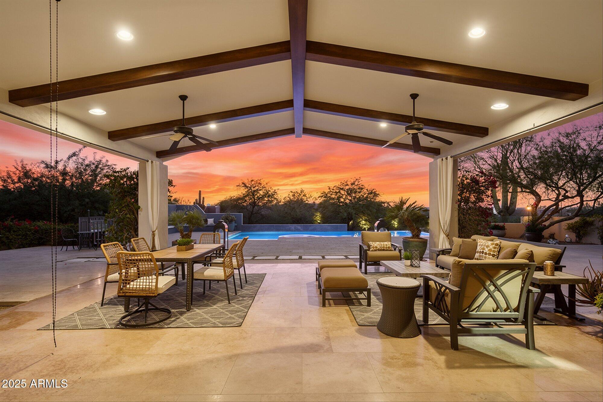 Set behind a private gate on 1.5 acres at the end of a quiet cul de sac in Pinnacle Peak Vistas, this home delivers serenity, privacy, thoughtful design, and seamless indoor-outdoor living with mountain and city light views. 6 bedrooms + office, 5.5 bathrooms, attached casita, and 4 car garage.
An open, generous great room anchors the layout with vaulted ceilings with wood beams, expansive windows, a two-way fireplace, and sliders that frame the desert landscape. 
The kitchen and dining area act as the heart of the home, offering quartzite counters, timeless neutral, warm-toned cabinetry, high-end appliances, a hidden walk-in pantry, and space for both casual and formal gatherings. 
A spacious family room opens to a grassy play area with mountain views, creating an easy, natural flow for everyday living. The split floor plan offers comfort and flexibility, with a serene primary suite featuring a sitting area, fireplace, private patio access, and a spa-inspired bath. Three additional ensuite bedrooms plus a versatile fourth room to support family, guests, or second office, golf simulator, theatre, home gym or hobbies. 
The attached casita adds even more flexibility with its own entrance to a suite with kitchenette, and private outdoor space, and full bathroom - ideal for multigenerational living or long-term guests.
Outdoor living takes center stage with a negative-edge pool overlooking the desert, covered patios for dining and lounging, a fire pit area, and a roof deck capturing sweeping mountain and city light views. Two separate oversized 2-car garages provide extensive storage and workspace. Paved driveway with fountain creates a grand entrance with ample parking for guests. This property blends privacy, views, and exceptional flow in a prime Scottsdale location, offering a lifestyle that is both relaxed and elevated. Great value and a wise investment.