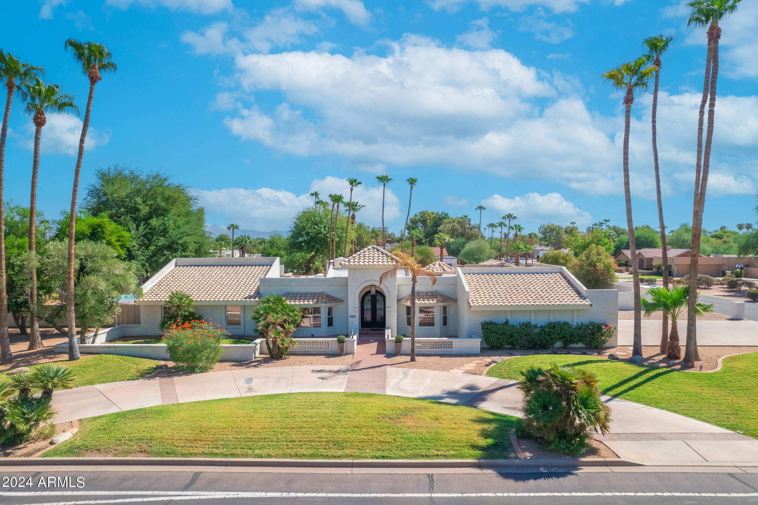 Welcome to ''Elegant Oasis in Paradise Valley''—a stunning blend of luxury, comfort, and sophisticated design. This exquisite 6-bedroom, 5-bathroom estate is situated on a highly sought-after corner lot in the heart of Paradise Valley, offering over 4,300 square feet of meticulously designed living space on just over an acre of land. As you step through the grand entrance, you'll be captivated by the home's impressive architecture and the perfect blend of modern elegance and timeless style. The gourmet kitchen serves as the centerpiece of the home, a striking granite waterfall island, sleek cabinetry, high-end stainless steel appliances, and a wet bar—ideal for hosting and entertaining guests. The open-concept layout flows seamlessly into the living room, where a cozy fireplace and beautiful wood-beamed ceilings create a warm, inviting atmosphere. For those who love movie nights, the custom theatre room provides a perfect retreat for family and friends. The spacious primary suite is a true sanctuary, featuring dual walk-in closets, a spa-like bathroom with a luxurious soaking tub, and an oversized walk-in shower. The secondary primary suite is equally impressive, offering its own en suite bathroom and direct access to the backyard. Shutters are featured throughout the entire home, adding privacy and style to every room. Step outside and discover your own private resort. The backyard is an entertainer's dream, complete with a heated pool featuring a waterfall, a relaxing spa, and plenty of patio space for outdoor dining and lounging. The sport court offers endless opportunities for recreation, while the meticulously landscaped grounds provide a serene and tranquil setting for relaxation. The property also features an RV gate for easy storage of recreational vehicles. Recent upgrades make this home truly turnkey. The flooring was completed in 2022, and the ceilings were raised the same year, enhancing the home's open, airy feel. The two AC units and pool pump were replaced in 2024 to ensure ultimate comfort and efficiency. A new tankless hot water heater and a water softener ensure convenience and energy savings. The three-car garage features epoxy flooring and a 220-volt outlet, perfect for charging electric vehicles. This property has been meticulously maintained and thoughtfully designed to maximize comfort and flow, blending indoor and outdoor living seamlessly. Whether you're hosting a large gathering or enjoying a quiet evening at home, this estate offers the ultimate in luxury and style. Located in one of Paradise Valley's most prestigious areas, this home is close to top-rated schools, world-class dining, and upscale shopping. Experience unparalleled luxury in Arizona.