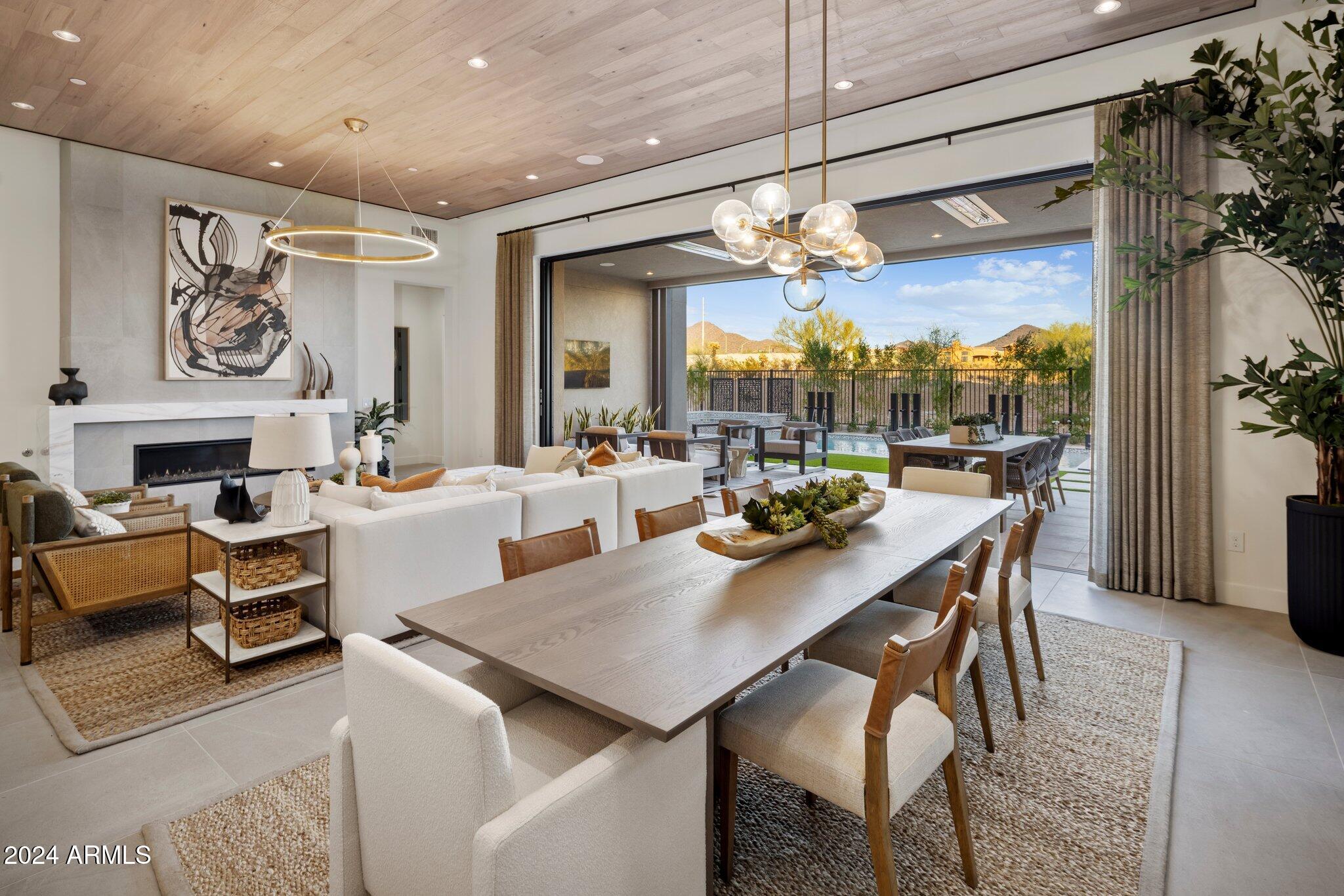 Welcome to your dream retreat! This exceptional model home effortlessly blends luxury, style, and comfort, offering everything you need for refined living. Located in a highly desirable Scottsdale neighborhood with breathtaking mountain views, this property showcases exquisite designer finishes and a layout that invites indoor-outdoor living at its finest.  The  kitchen features custom cabinetry and a striking marble waterfall countertop. Outfitted with top-of-the-line Wolf/Sub-Zero appliances, this kitchen is ideal for entertaining.  The expansive open-concept great room, features pocketing doors that seamlessly extend your living space to the outdoors.  The pool and spa are complete with a serene waterfall feature surrounded by a lushly landscaped yard for ultimate relaxation.