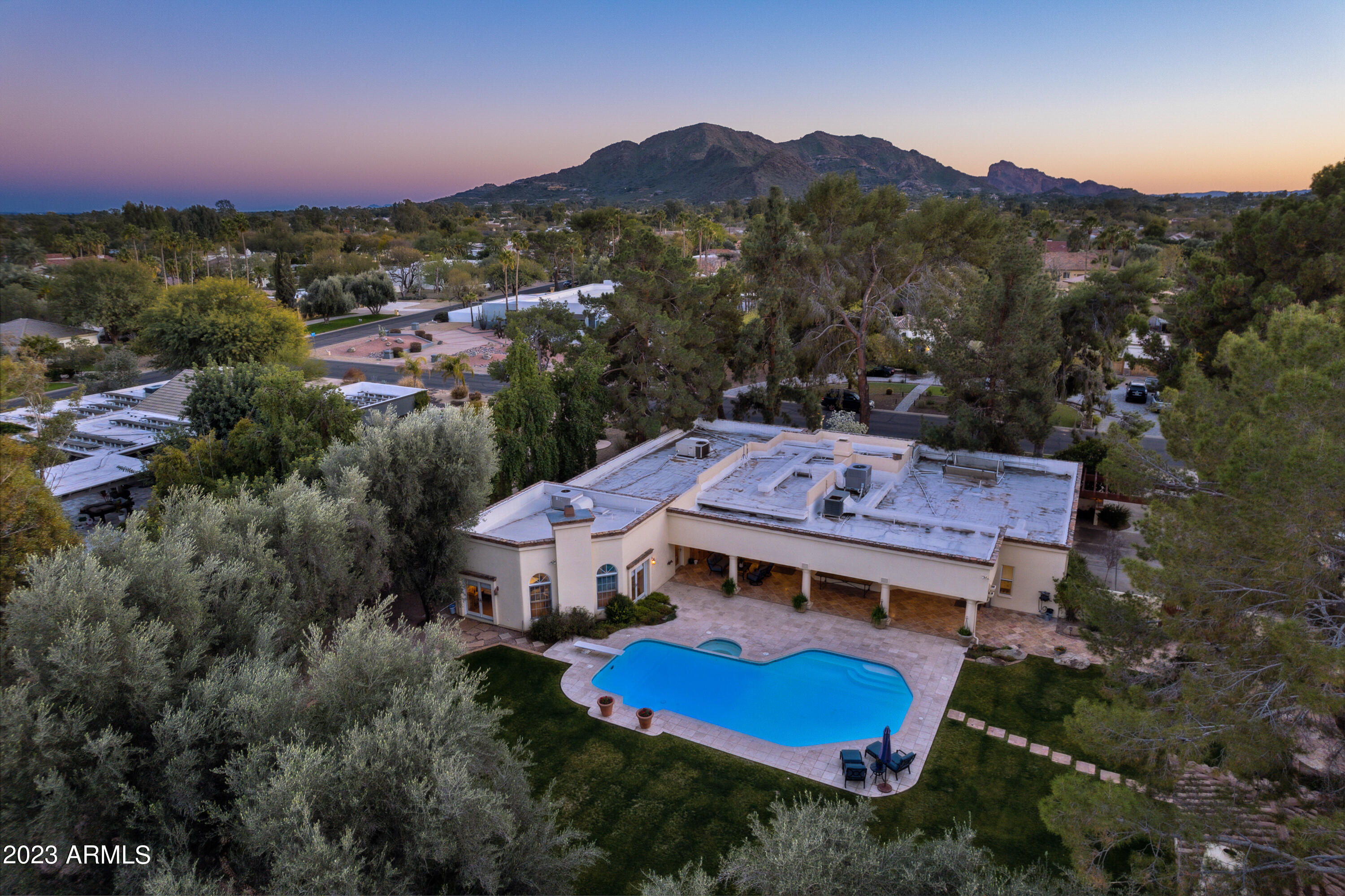 Discover the warm charm of this stunning Paradise Valley residence, located in the highly coveted Tatum Green Estates and within the revered 3 C's school boundaries. Set on a sprawling 1-acre lot, surrounded by mature and beautiful landscaping, this property features a sparkling pool and a stunning guest casita. 

As you approach this estate, the circular drive will impress, and the lush grounds will leave a lasting impression. Upon entering the home through the charming courtyard, you'll be greeted by the beautiful herringbone brick floors in the living room, which flow seamlessly into the engineered French oak wood floors in the main living areas. The family room opens to a gourmet kitchen, equipped with high-end appliances, custom cabinetry, quartz counters, and a walk-in pantry, along with a climate-controlled wine closet to preserve your fine wine collection.

The main home boasts 4 bedrooms, 3 full baths, and a powder room, all designed with luxury in mind. The master suite is a true masterpiece, with 12ft ceilings, a stunning brick feature wall, a cozy fireplace, and plenty of natural light. The study off the master suite is fantastic additional space in the home.

The guest casita, complete with its own bath and partial kitchen, provides comfort and privacy for your guests, and has its own 2 car garage. With the additional 3 car garage attached to the main home you will have plenty of space to store your favorite cars and toys. There is lots of built-in storage in both garages which is an added bonus. 

Unwind outside in your own private oasis surrounded by lush landscaping as well as a sparkling pool for those hot summer days. The large backyard is perfect for entertaining with the oversized covered patio, ramada, and mature fruit trees.

This breathtaking estate is conveniently located close to shopping, dining, entertainment, and more. Don't miss this rare opportunity to own a piece of paradise in the heart of Paradise Valley.