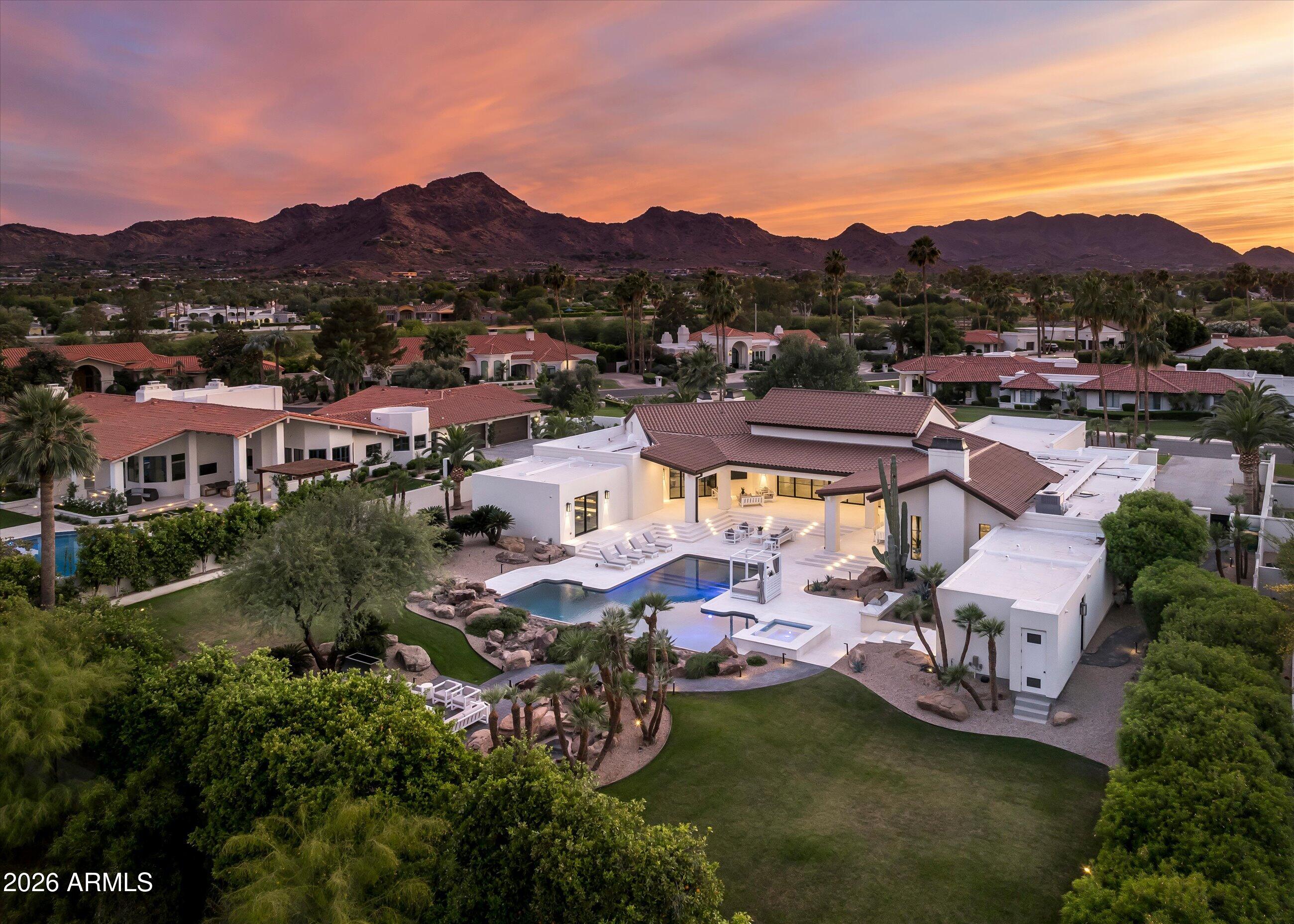 A quiet estate, finished twice. Set behind a custom steel gate on more than an acre in Camelback Country Estates, this single-level Paradise Valley residence has been fully reimagined and then refined again -- and it shows. The chef's kitchen is anchored by Public House Creative cabinetry, a fluted concrete hood, and a pass-through window to the outdoor bar. Throughout the home -- kitchen, bar, casita, and wellness studio -- a 19-piece Wolf and Sub-Zero appliance package. Lime-plaster fireplaces. White oak throughout. A dark, cinematic office wrapped in custom millwork. A primary suite with adjoining wellness studio that opens directly to the pool. Outside, imported Turkish limestone hardscape, a new accessible spa beside the heated pool, an outdoor fireplace seating area, and Camelback in the distance. The current owner added the home's whole-home Crestron automation -- lighting, motorized shades, climate, audio, and surveillance -- and the full pavered hardscape, front and back, the new spa, and more. Six new variable-speed Carrier HVAC units. New Pella throughout. A separate casita with private entry. Excellent location. A home built for the way you actually live now.