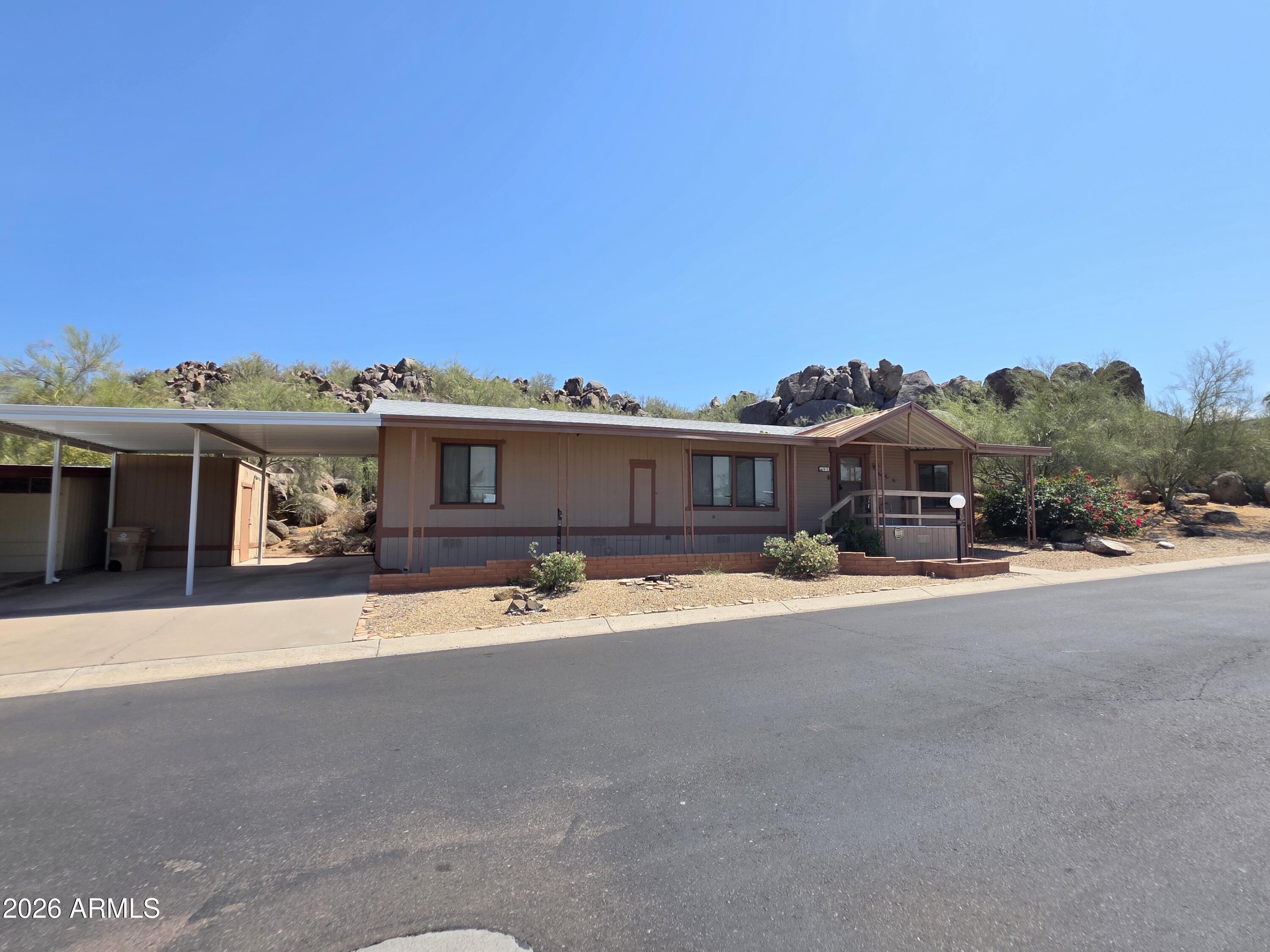 Great opportunity to own a mountainside home with a rare backyard setting showcasing magnificent mountain and boulder views--tranquility at its best. This spacious 18x60 single-wide offers 1,080 sq ft with a split floor plan, laminate flooring in kitchen and bedrooms, large bedrooms with walk-in closets, and a generous pantry. Home has great potential to update to your own style. Enjoy the large rebuilt wood deck overlooking stunning boulders, mountains, nature, and wildlife, creating one of the most peaceful settings in the community. Located in Boulder Ridge, a gated 55+ community. Buyer must be park approved: 750+ credit score, verifiable income 3x lot rent, proof of savings equal to 6x lot rent, and background check. Lot rent $1,010/month.